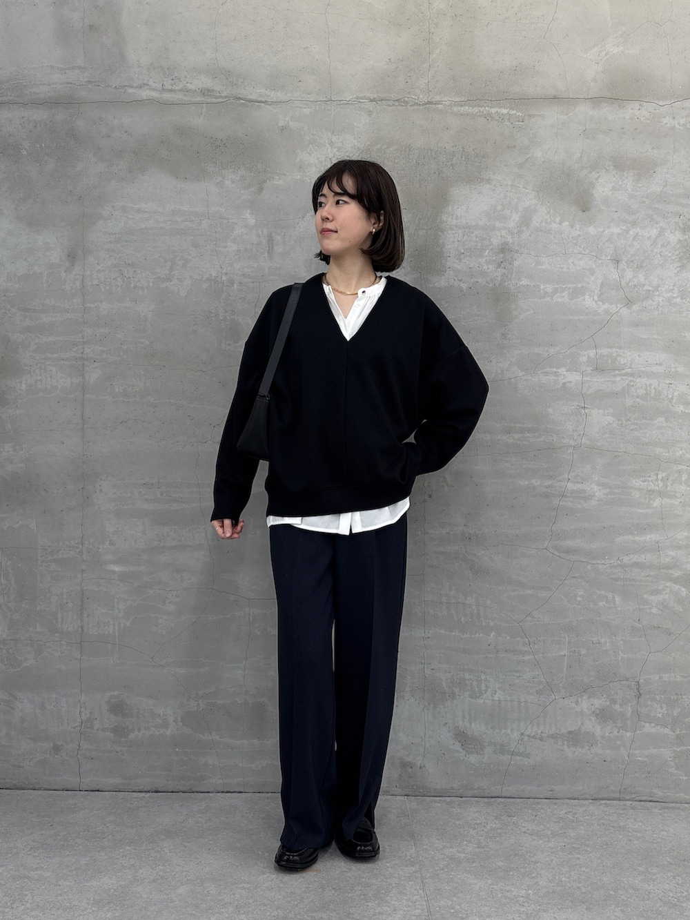 ブラック系のTシャツ/カットソー、ブルー系のスラックス、ホワイト系のシャツ/ブラウスを着用したレディースの冬コーディネートの2枚目の写真