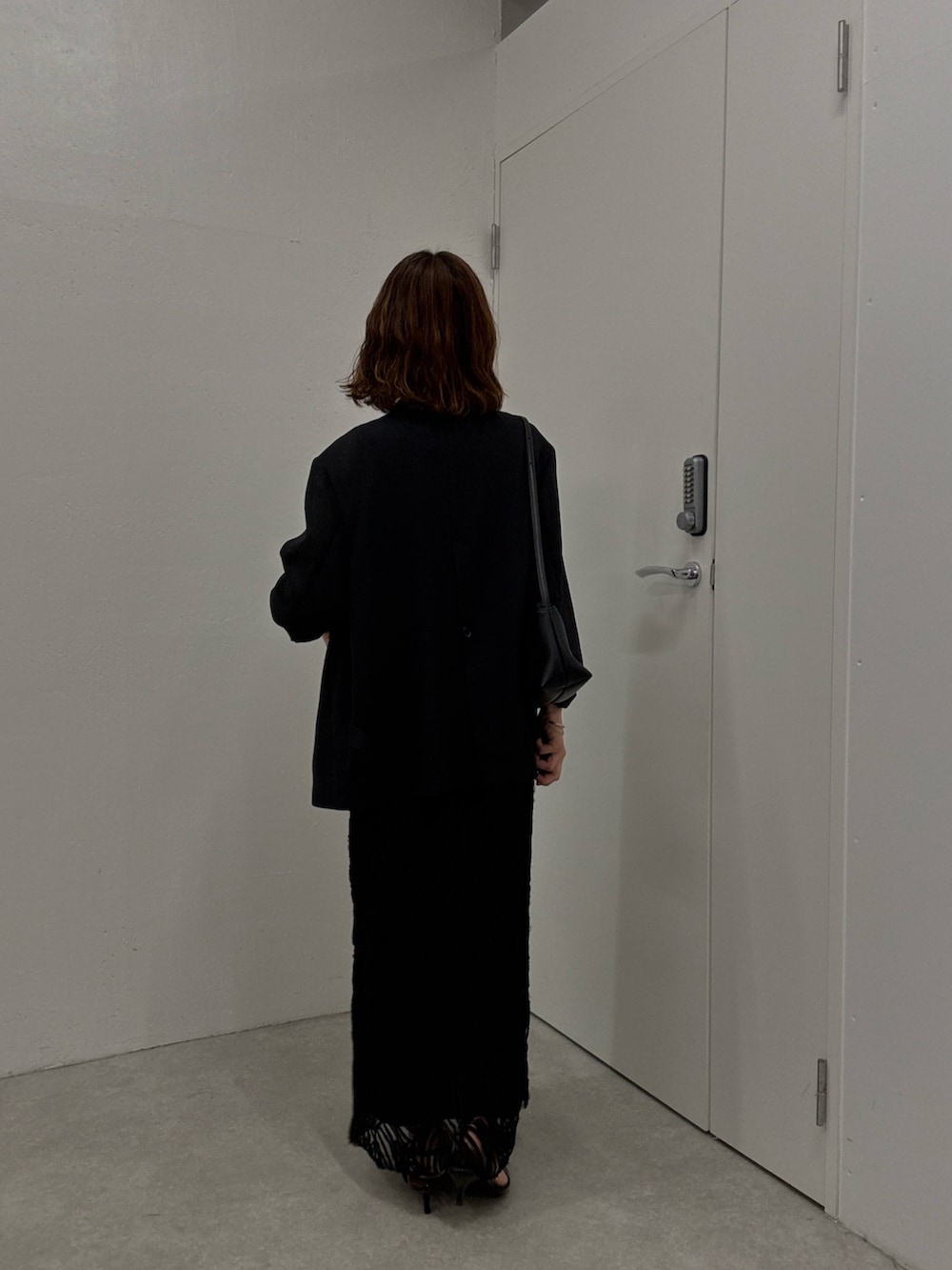 ブラック系のワンピース、ブラック系のテーラードジャケット、ブラック系のパンプスを着用したレディースの夏コーディネートの3枚目の写真