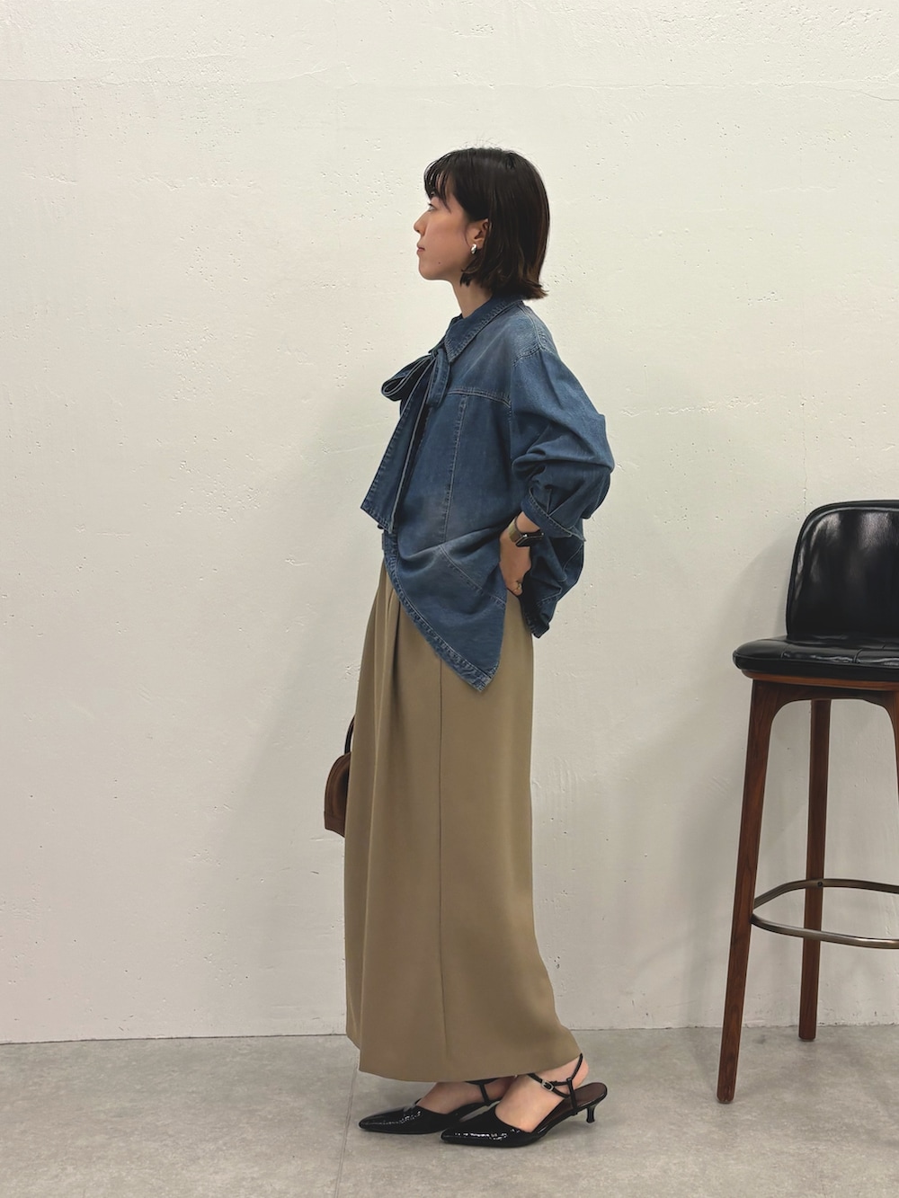 ブルー系のシャツ/ブラウス、ベージュ系のスカート、ブラック系のパンプスを着用したレディースの秋コーディネートの2枚目の写真