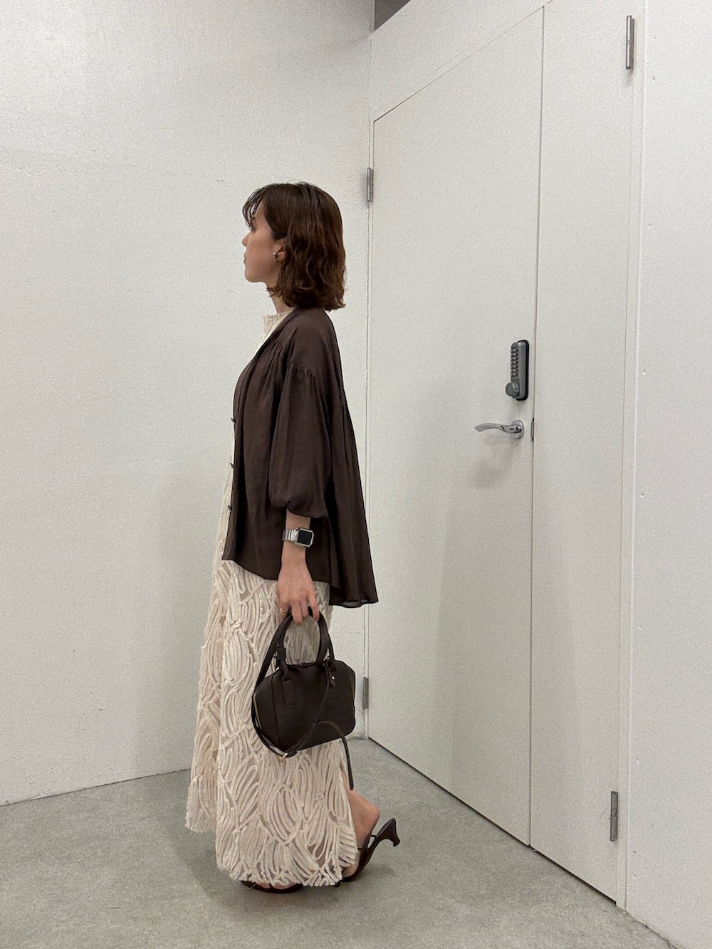 ブラウン系のシャツ/ブラウス、ホワイト系のワンピース、ブラウン系のショルダーバッグを着用したレディースの夏コーディネートの2枚目の写真