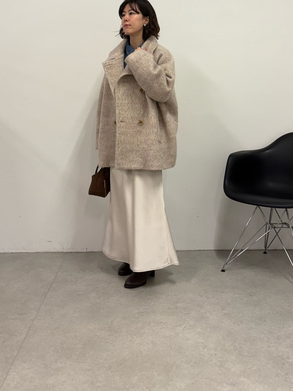 ホワイト系のスカート、ブラウン系のボストンバッグ、ブラウン系のブーツを着用したレディースの秋コーディネートの2枚目の写真