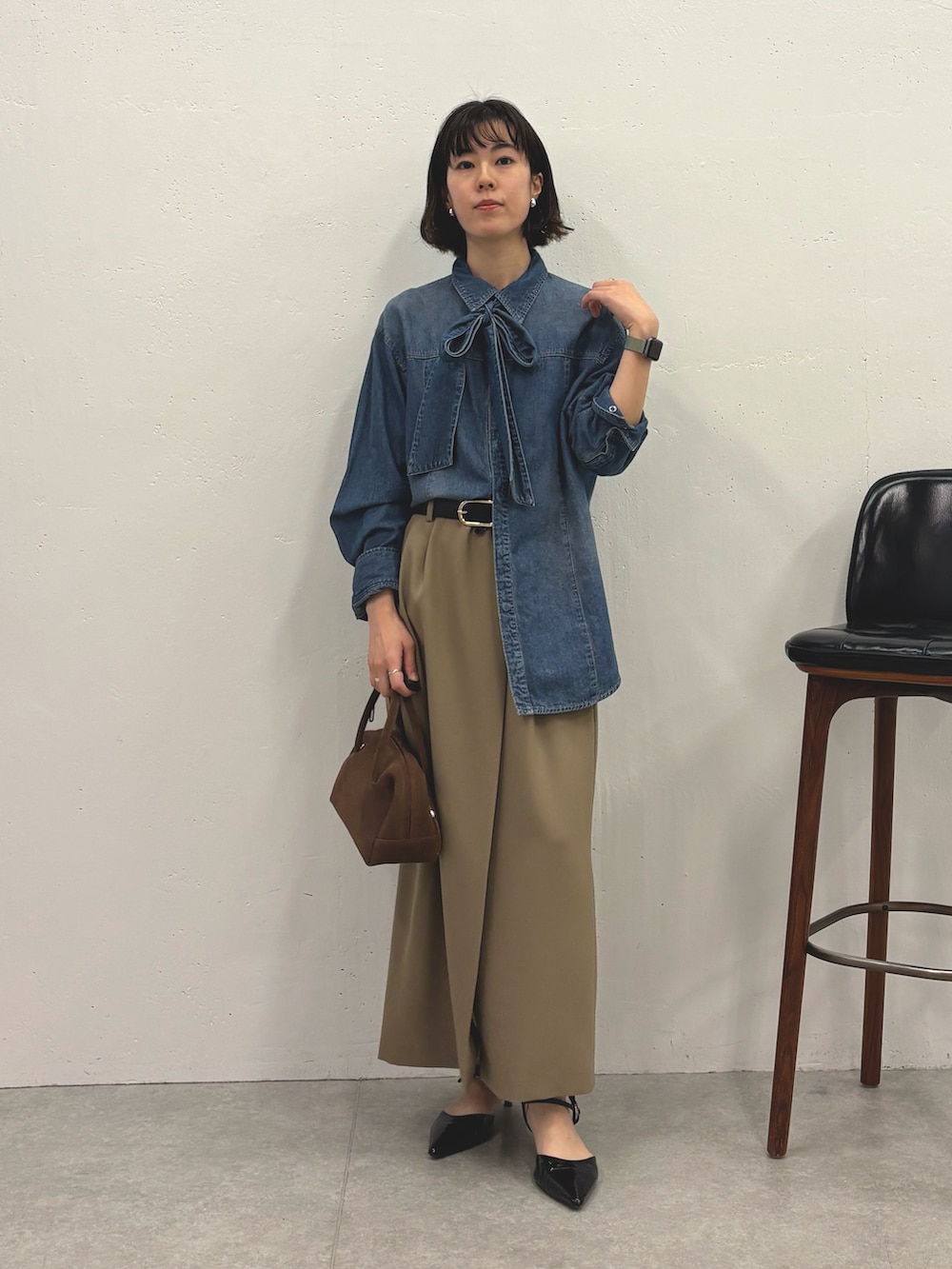 ブルー系のシャツ/ブラウス、ベージュ系のスカート、ブラック系のパンプスを着用したレディースの秋コーディネートの4枚目の写真