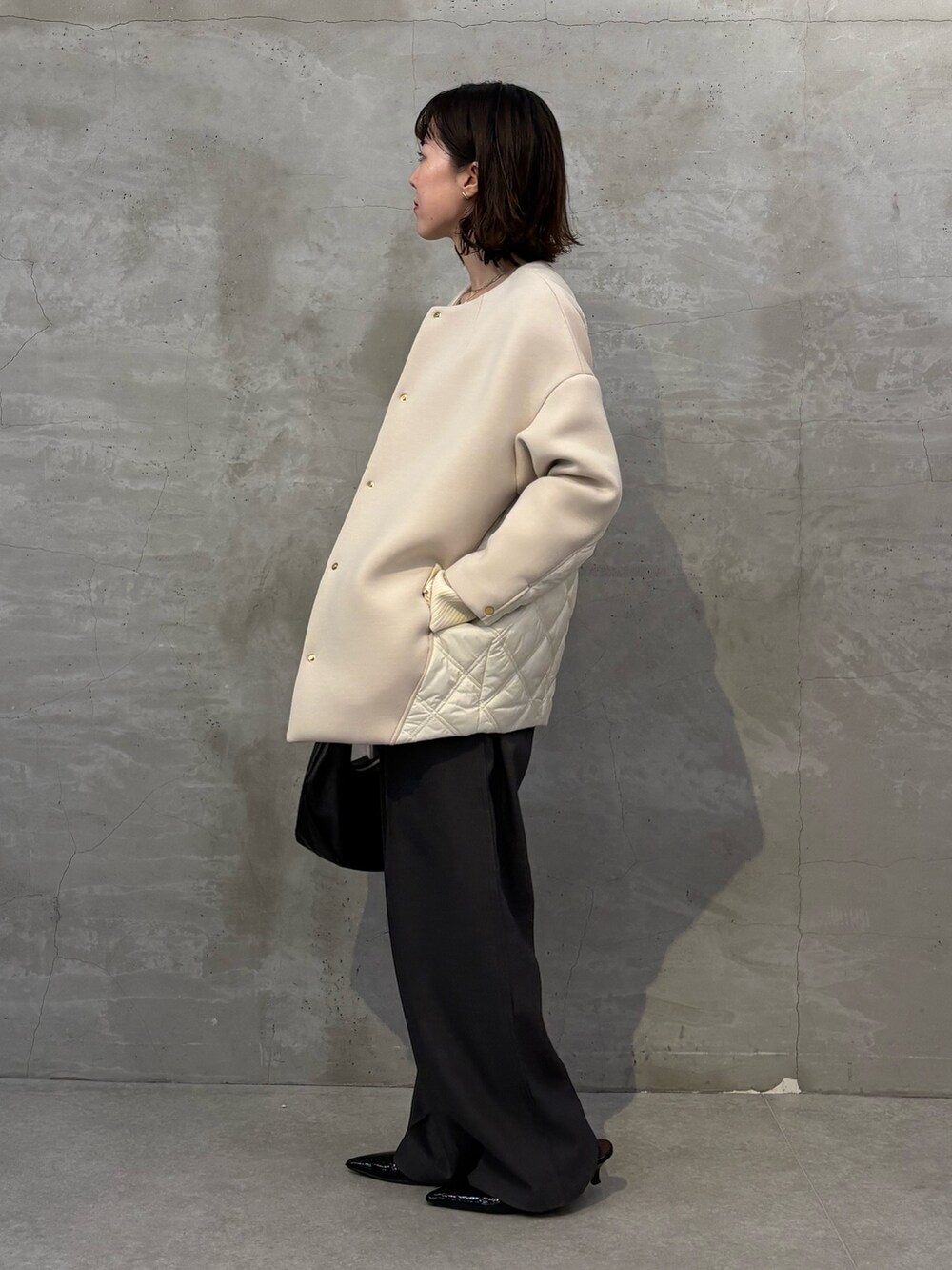 ベージュ系のその他アウター、ブラック系のショルダーバッグ、グレー系のスラックスを着用したレディースの秋コーディネートの2枚目の写真