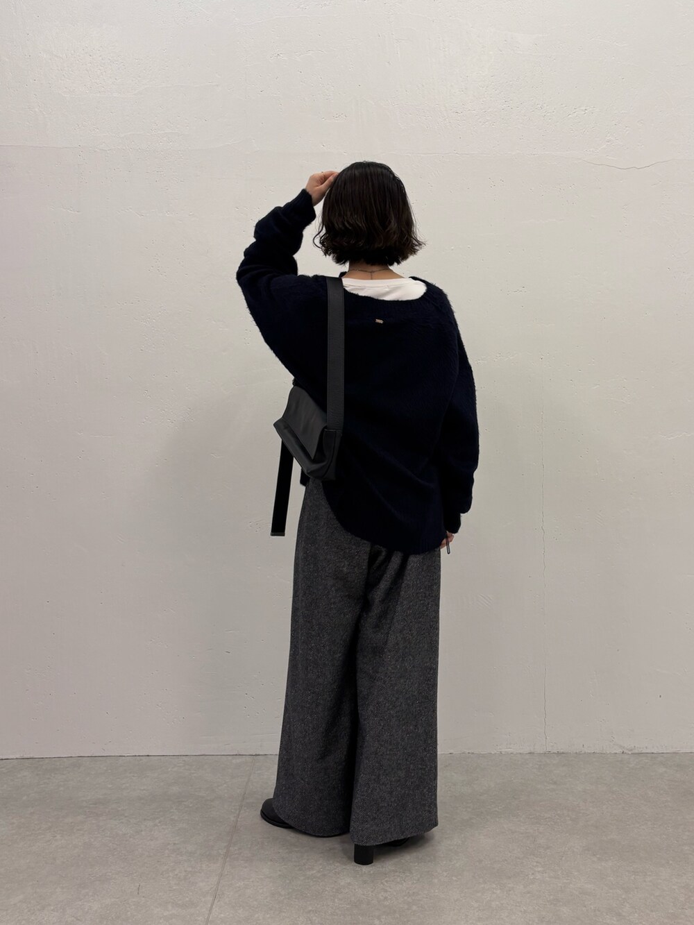 ブラック系のデニムパンツ、ホワイト系のTシャツ/カットソー、ブルー系のニット/セーターを着用したレディースの秋コーディネートの2枚目の写真