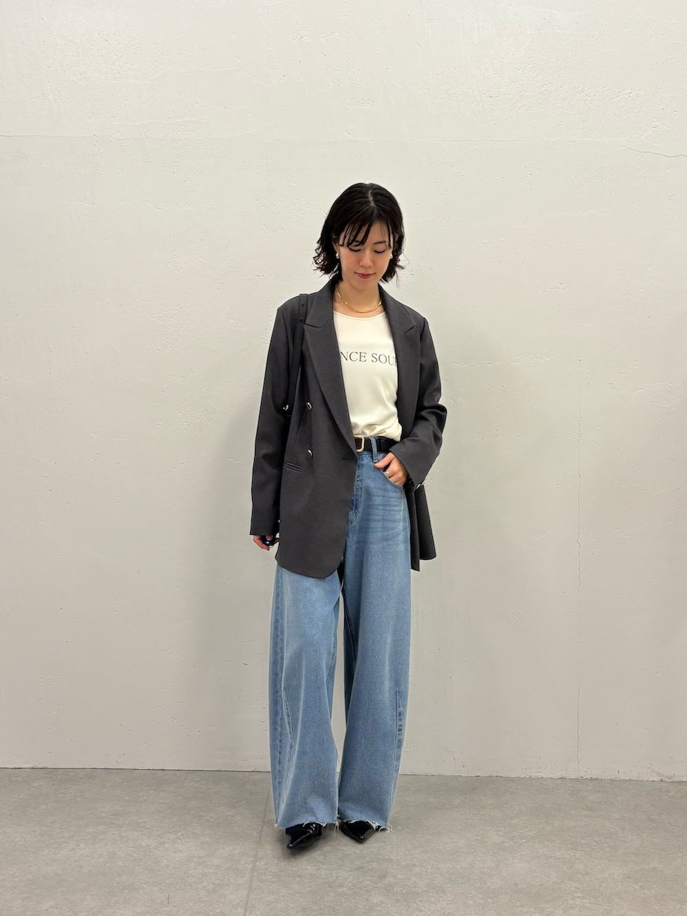 ホワイト系のTシャツ/カットソー、グレー系のテーラードジャケット、ブルー系のデニムパンツを着用したレディースの秋コーディネートの5枚目の写真