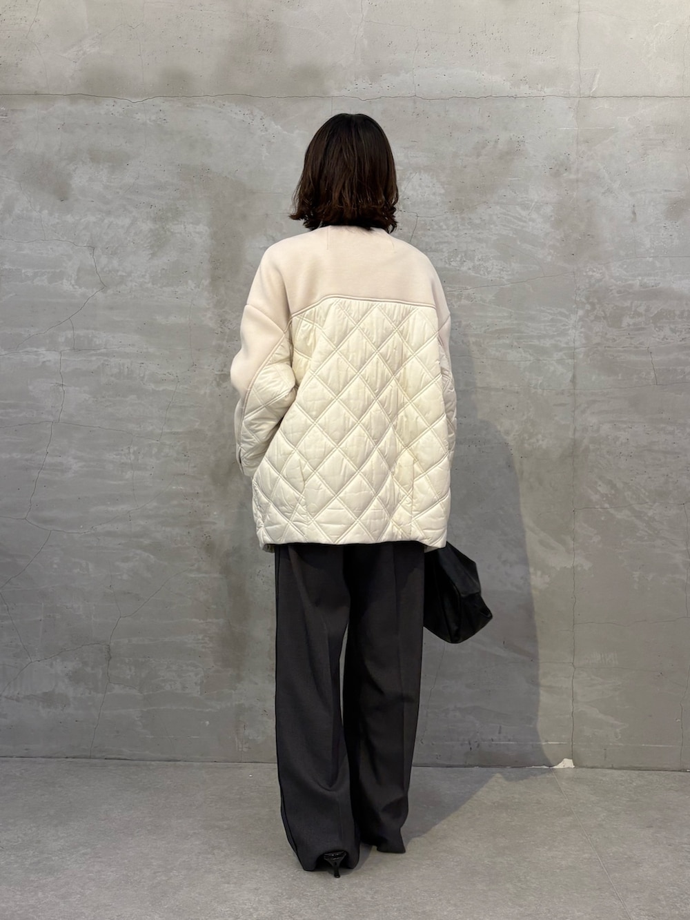 ベージュ系のその他アウター、ブラック系のショルダーバッグ、グレー系のスラックスを着用したレディースの秋コーディネートの3枚目の写真