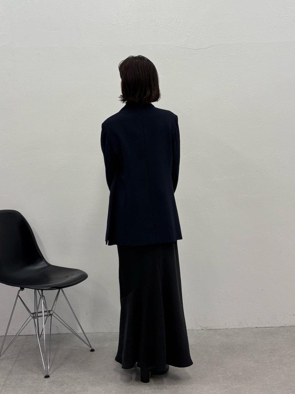 ブラック系のスカート、ブルー系のテーラードジャケット、ブラック系のボストンバッグを着用したレディースの冬コーディネートの3枚目の写真