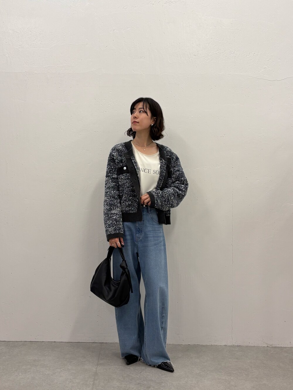 ブラック系のパンプス、ブラック系のショルダーバッグ、ホワイト系のTシャツ/カットソーを着用したレディースの秋コーディネートの4枚目の写真