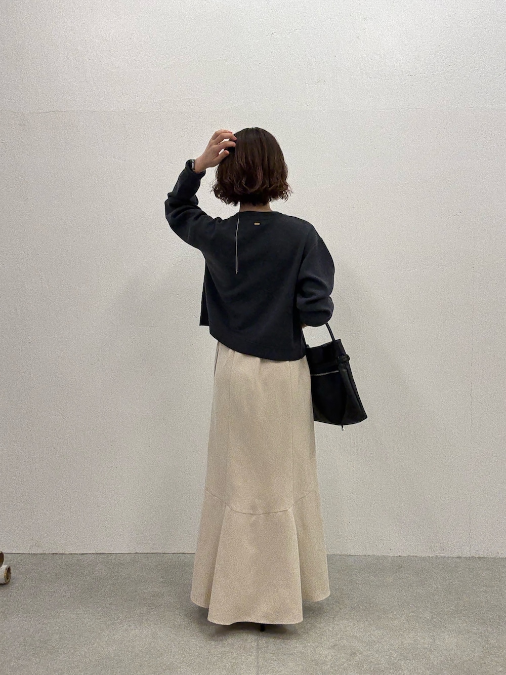 グレー系のカーディガン/ボレロ、ホワイト系のスカート、ブラック系のトートバッグを着用したレディースの夏コーディネートの3枚目の写真