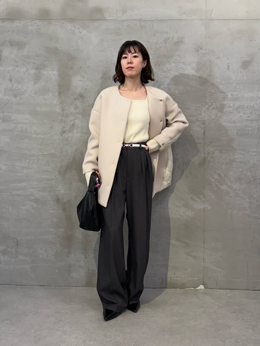 ベージュ系のその他アウター、ブラック系のショルダーバッグ、グレー系のスラックスを着用したレディースの秋コーディネートの4枚目の写真
