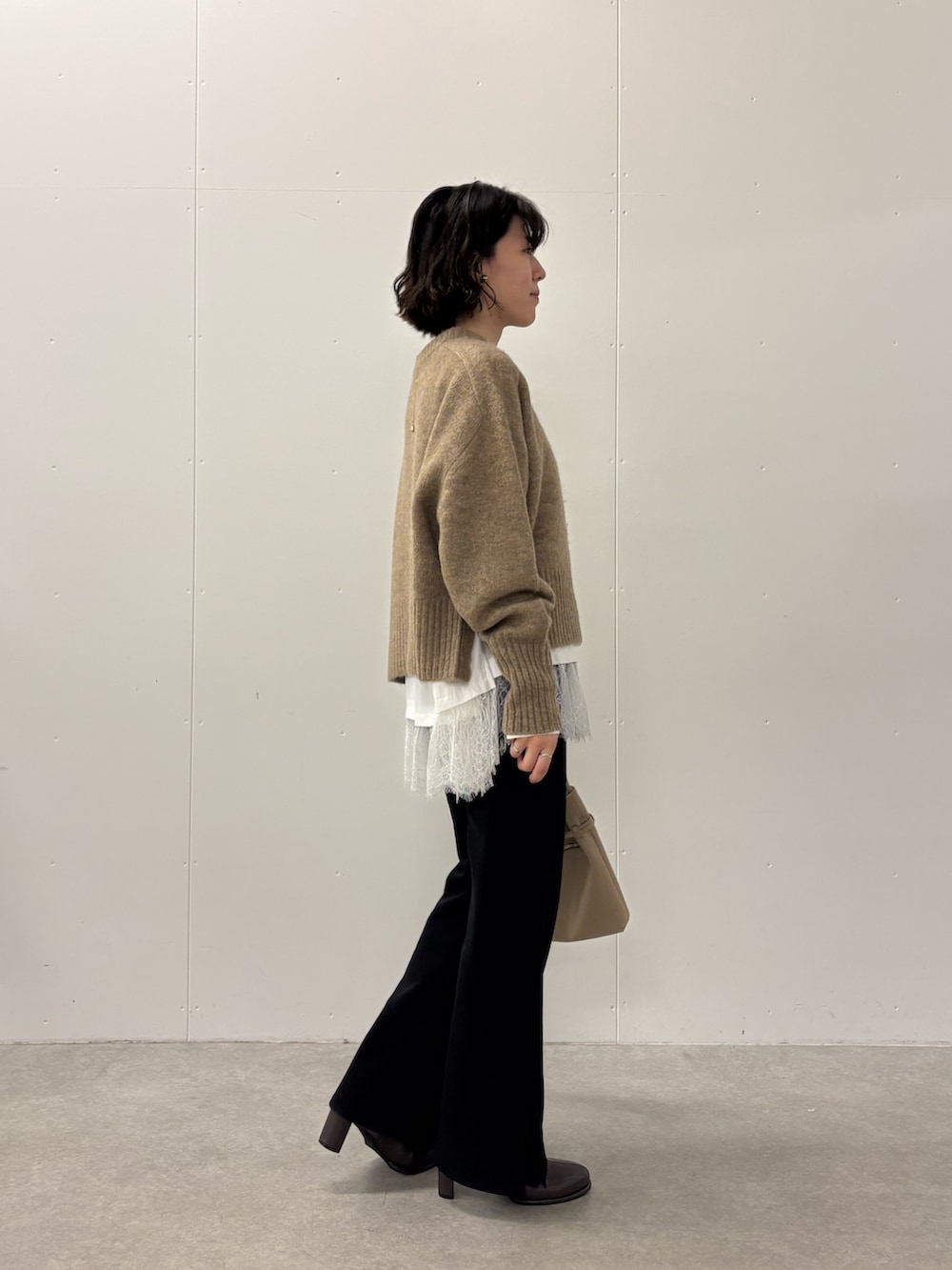 ブラック系のその他パンツ、ブラウン系のニット/セーター、ホワイト系のシャツ/ブラウスを着用したレディースの秋コーディネートの2枚目の写真
