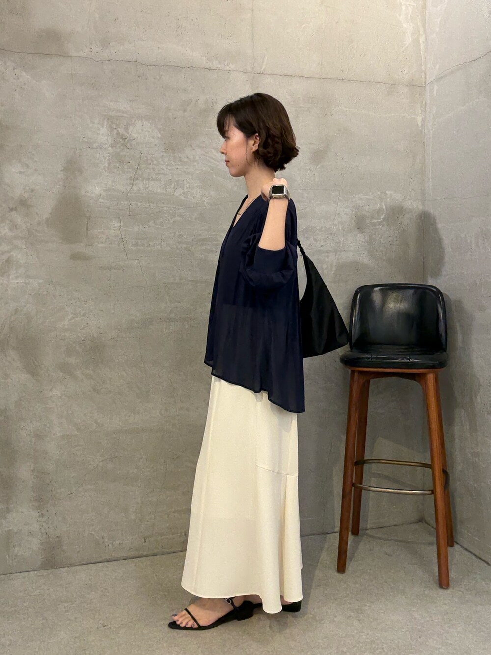 ホワイト系のスカート、ブラック系のショルダーバッグ、ブルー系のシャツ/ブラウスを着用したレディースの夏コーディネートの2枚目の写真