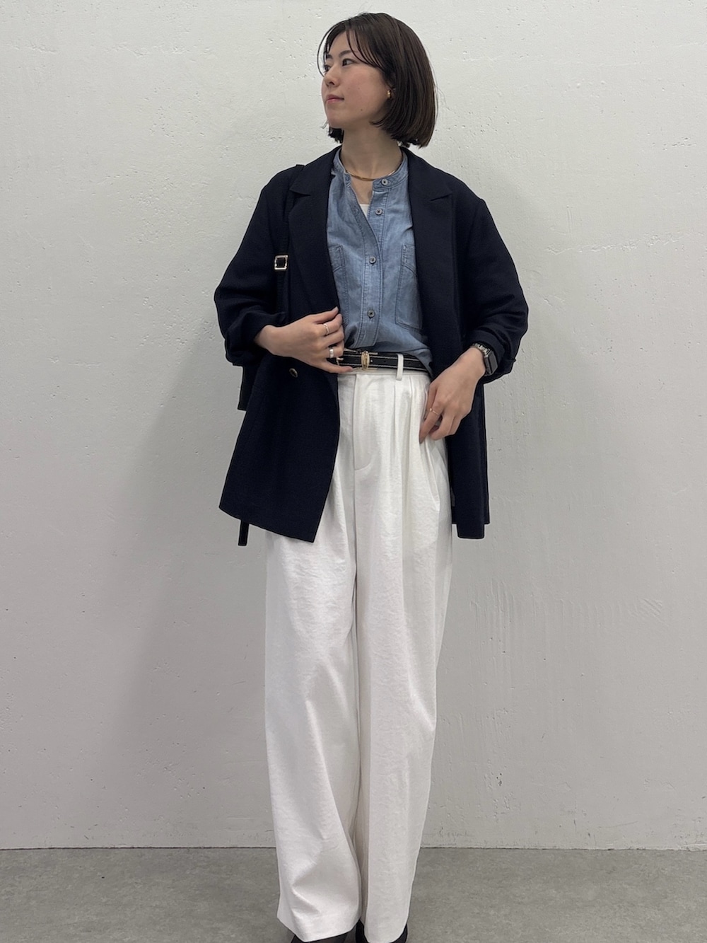 ホワイト系のスラックス、ブルー系のテーラードジャケット、ブラック系のサンダルを着用したレディースの春コーディネートの5枚目の写真