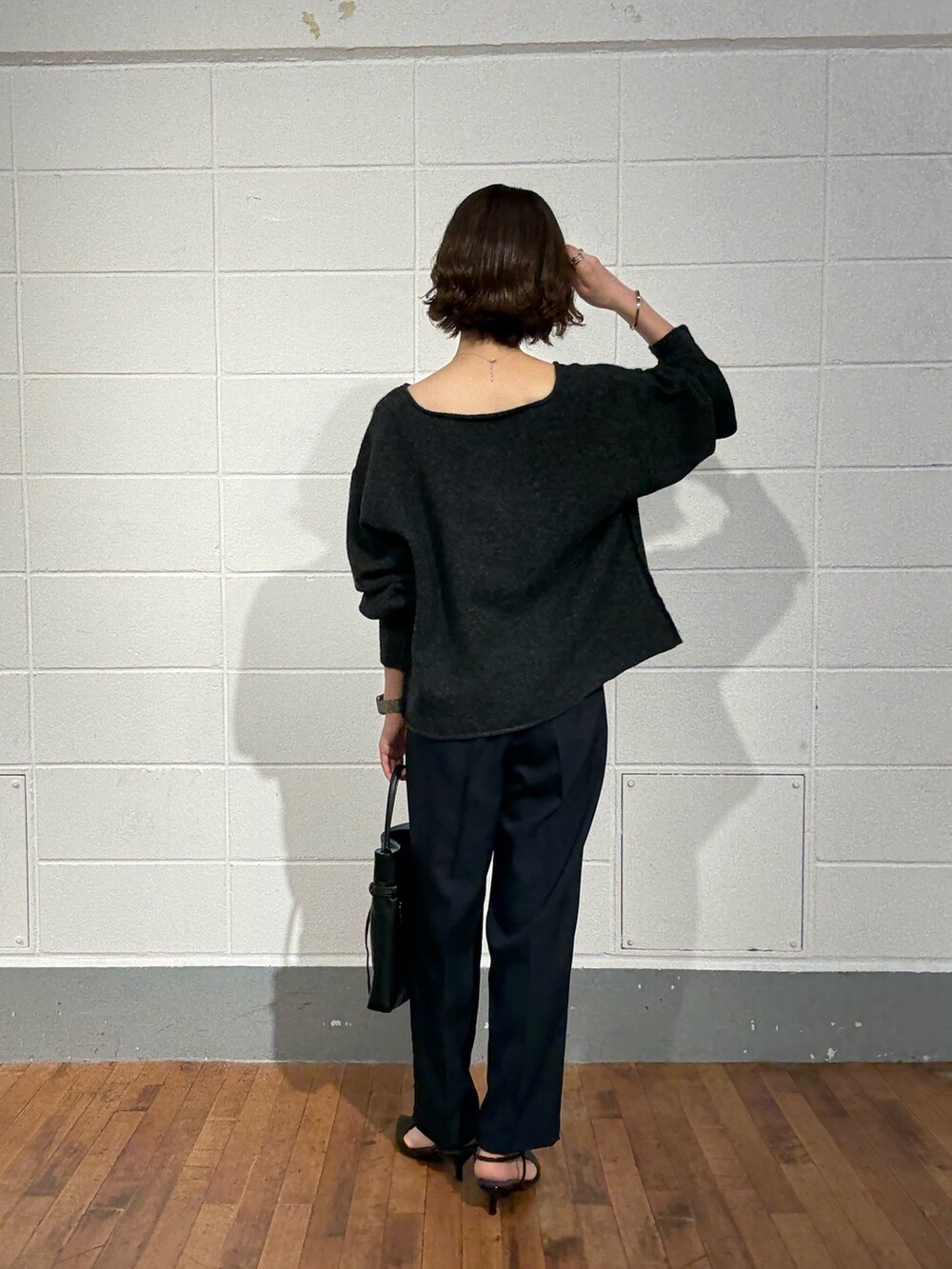 グレー系のニット/セーター、ブルー系のその他パンツ、ブラック系のトートバッグを着用したレディースの秋コーディネートの3枚目の写真