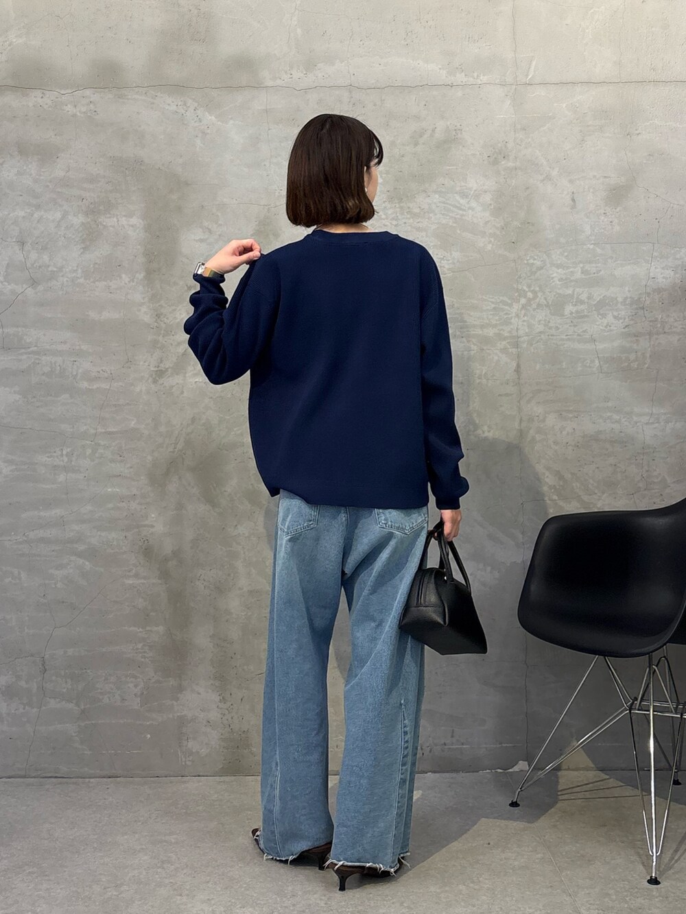 ブルー系のデニムパンツ、ブラック系のボストンバッグ、ブルー系のカーディガン/ボレロを着用したレディースの冬コーディネートの3枚目の写真