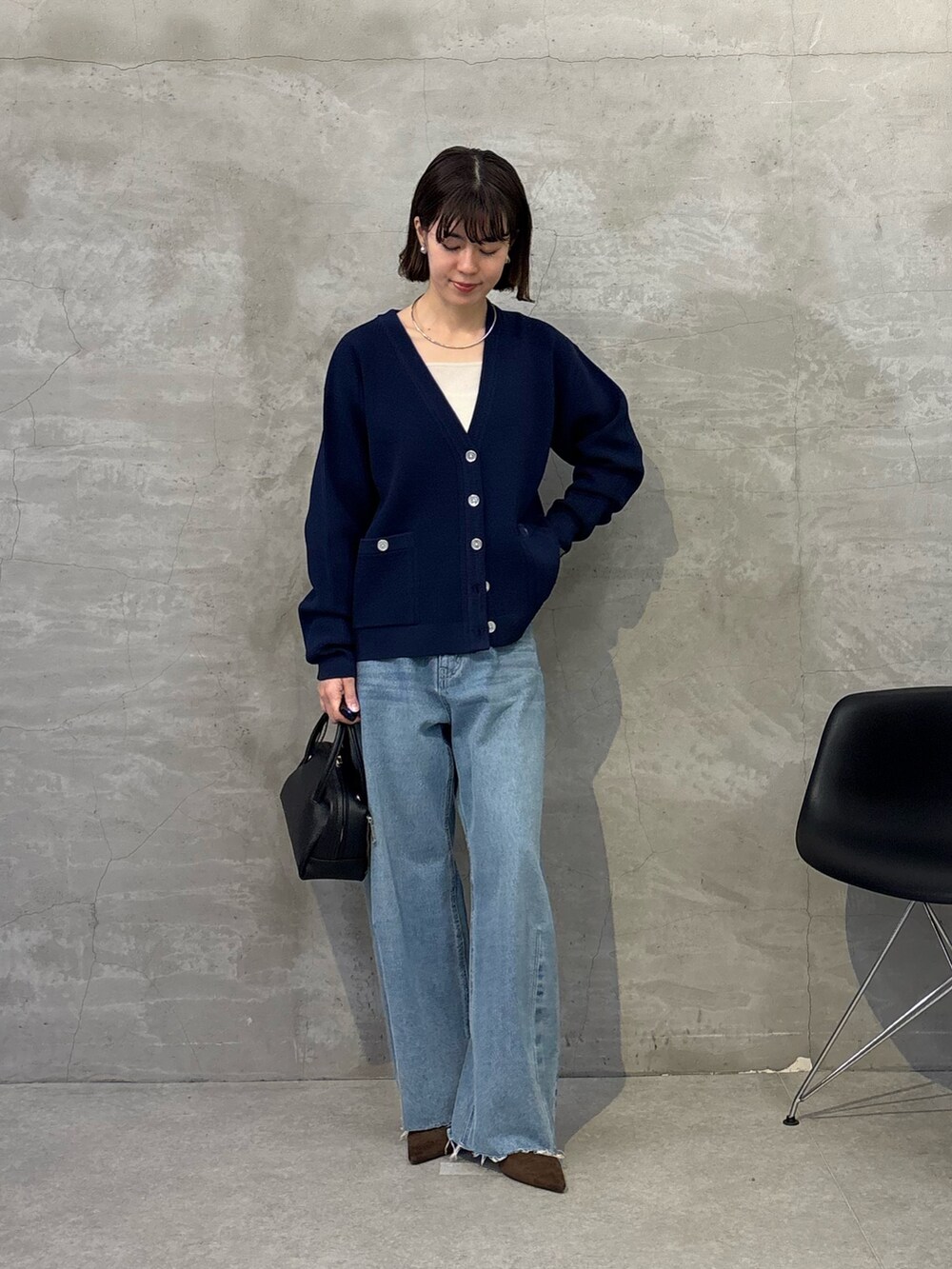 ブルー系のデニムパンツ、ブラック系のボストンバッグ、ブルー系のカーディガン/ボレロを着用したレディースの冬コーディネートの5枚目の写真