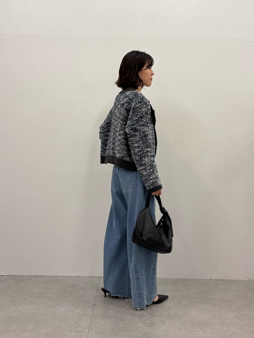 ブラック系のパンプス、ブラック系のショルダーバッグ、ホワイト系のTシャツ/カットソーを着用したレディースの秋コーディネートの2枚目の写真