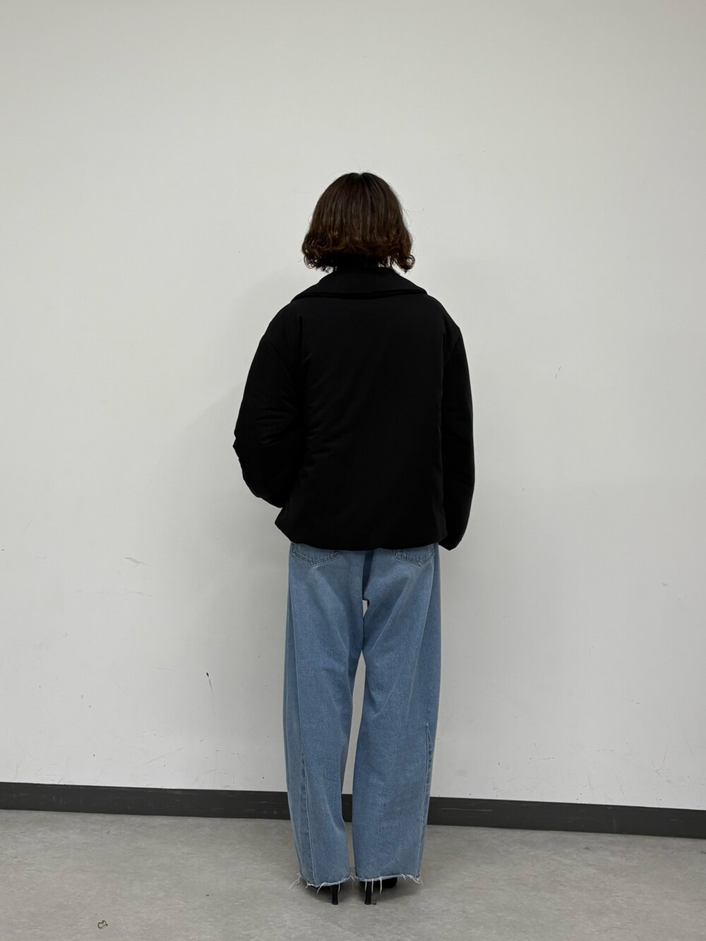 ブラック系のその他アウター、ブルー系のデニムパンツ、ホワイト系のニット/セーターを着用したレディースの秋コーディネートの3枚目の写真