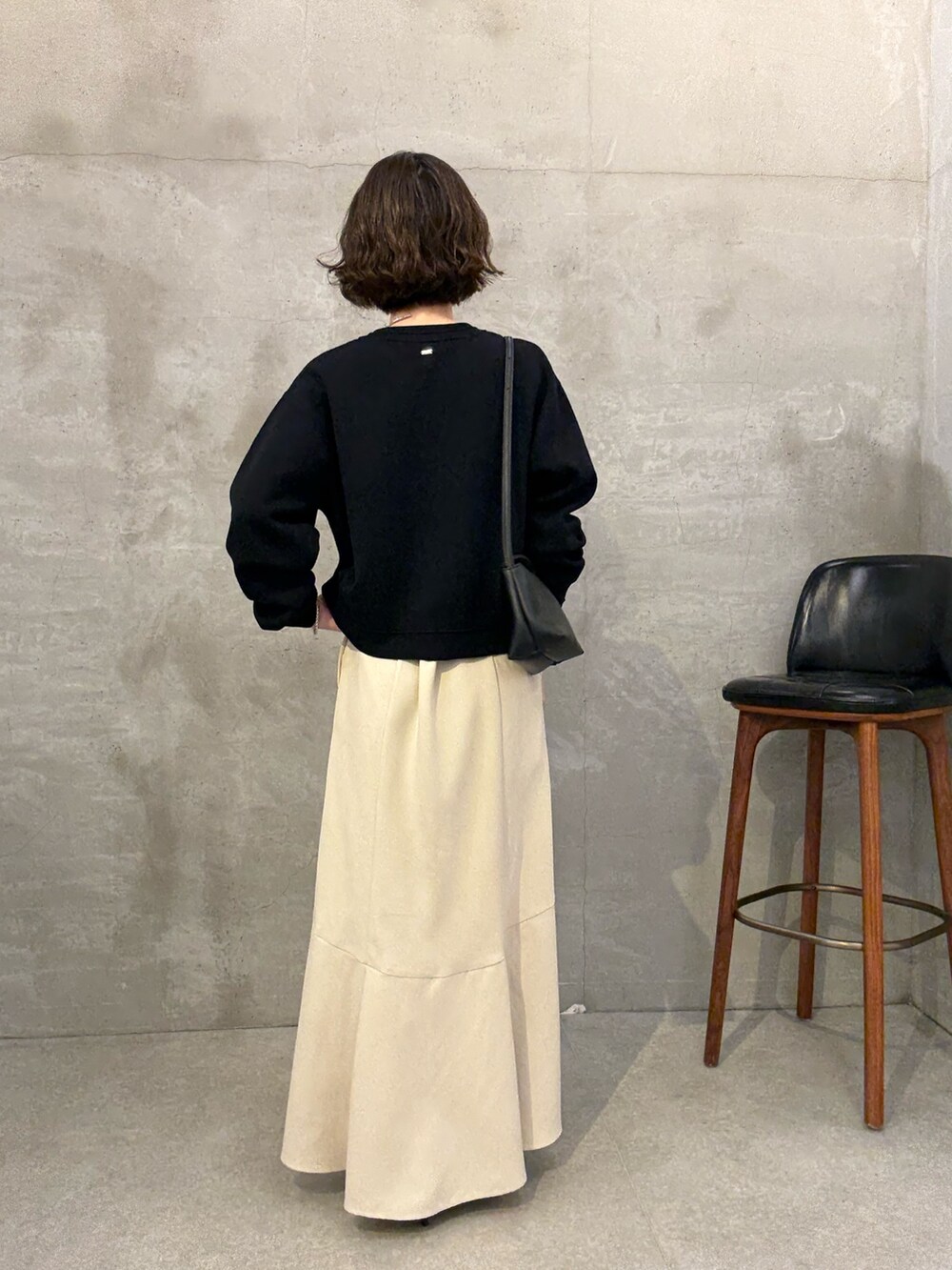 ホワイト系のスカート、ブルー系のカーディガン/ボレロ、ブラック系のショルダーバッグを着用したレディースの夏コーディネートの2枚目の写真