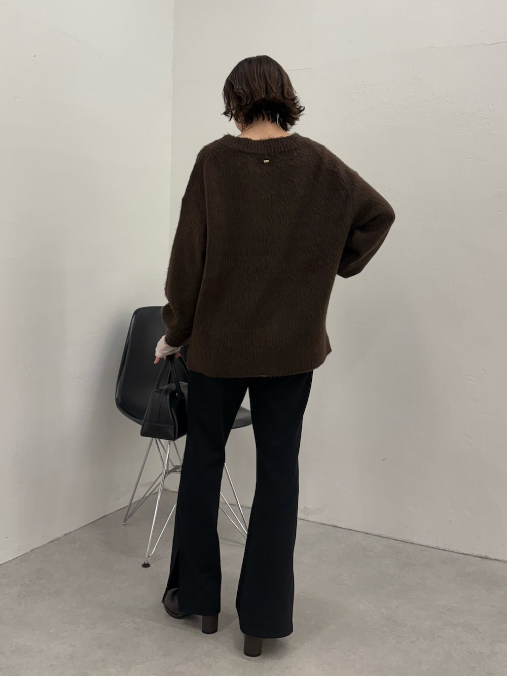 ブラック系のその他パンツ、ブラック系のボストンバッグ、ブラック系のブーツを着用したレディースの秋コーディネートの3枚目の写真