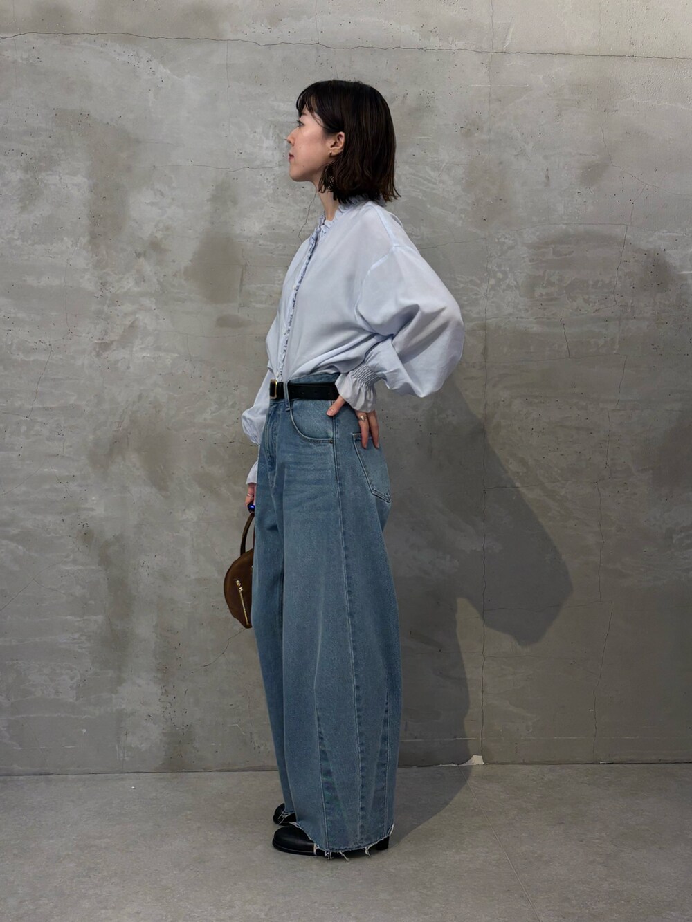 ブラック系のブーツ、ブラウン系のボストンバッグ、ブルー系のシャツ/ブラウスを着用したレディースの秋コーディネートの2枚目の写真