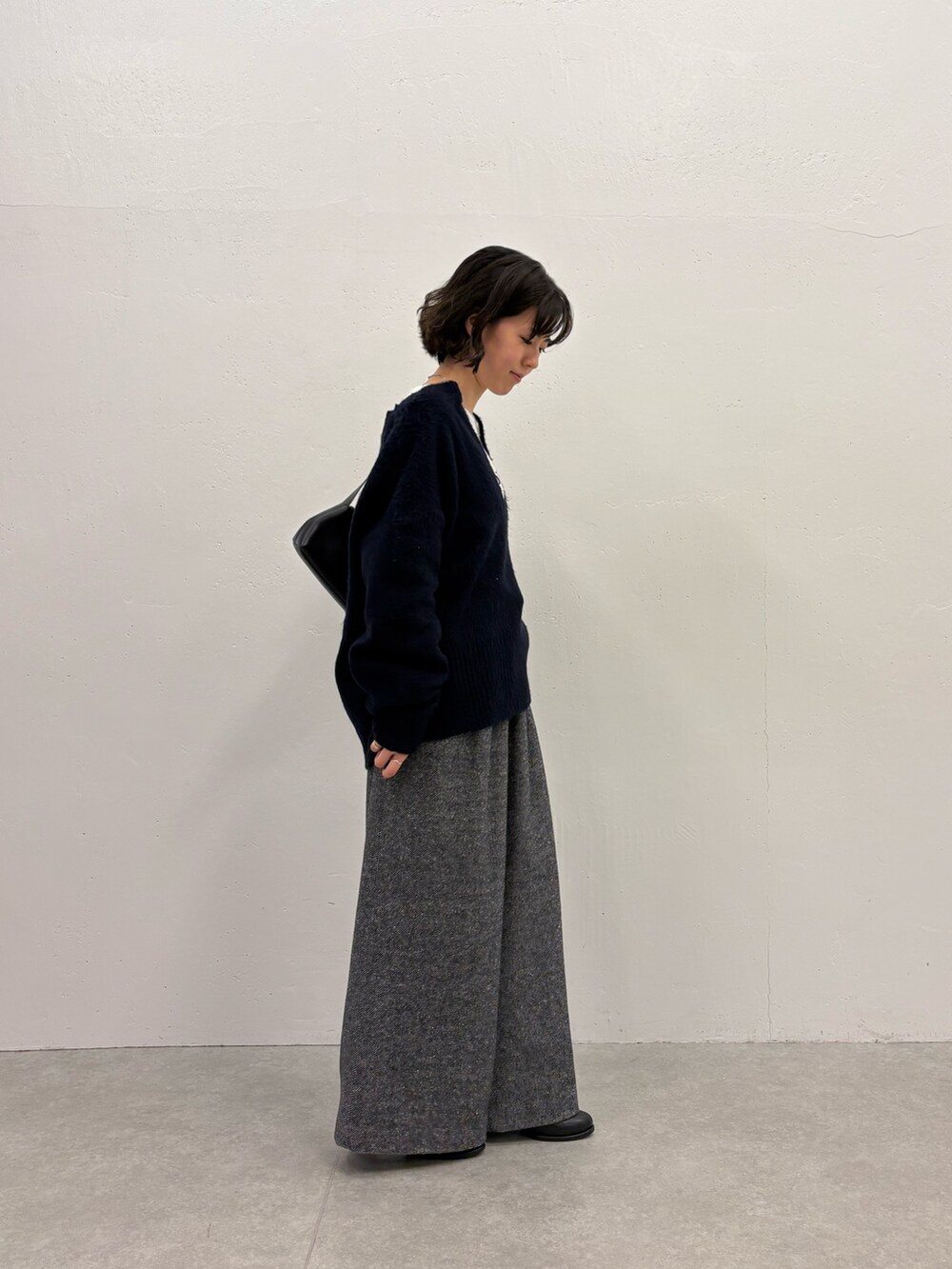 ブラック系のデニムパンツ、ホワイト系のTシャツ/カットソー、ブルー系のニット/セーターを着用したレディースの秋コーディネートの3枚目の写真