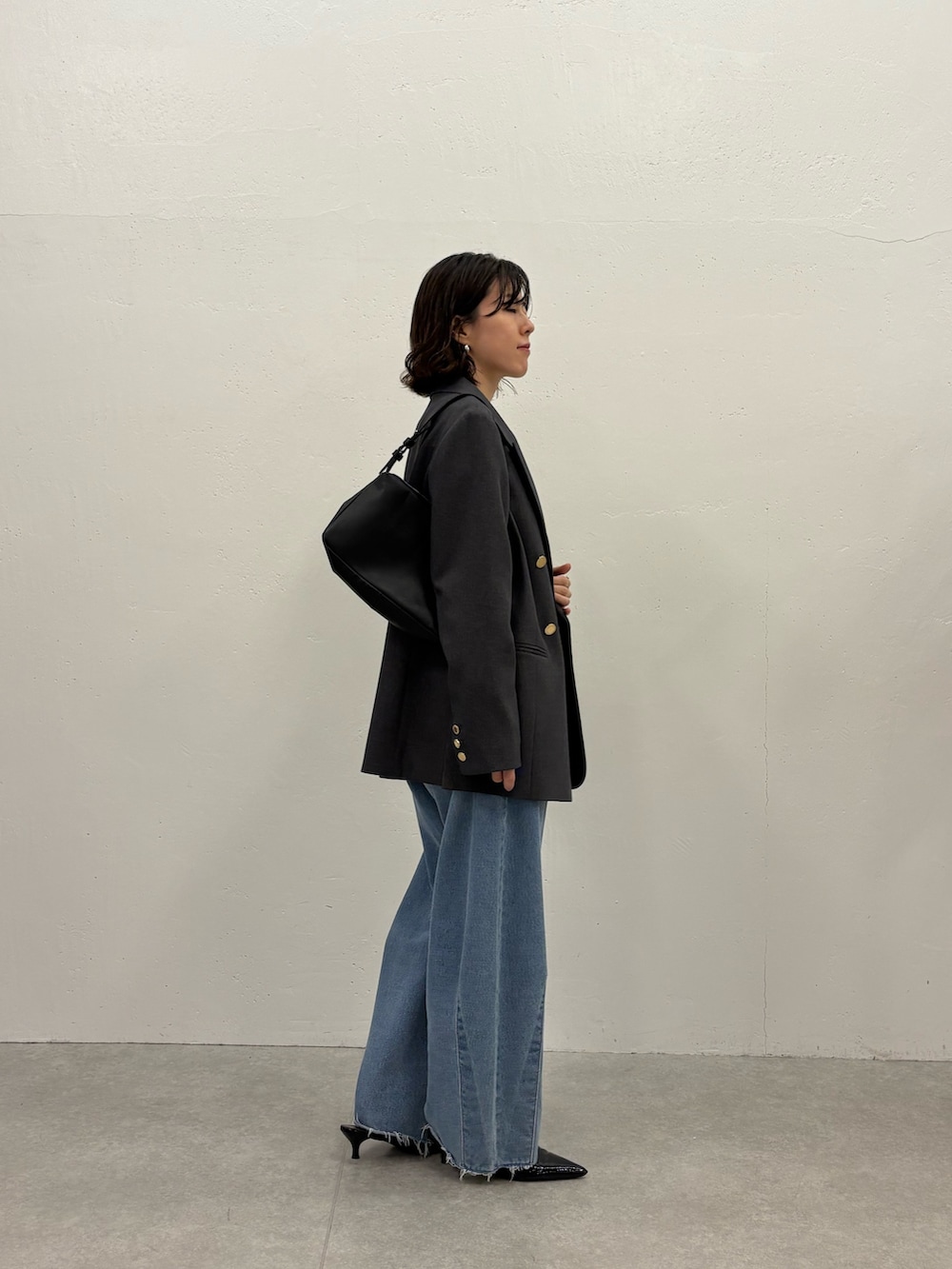 ホワイト系のTシャツ/カットソー、グレー系のテーラードジャケット、ブルー系のデニムパンツを着用したレディースの秋コーディネートの4枚目の写真