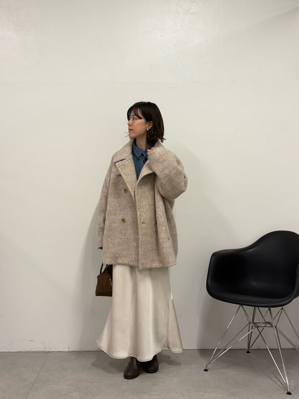 ホワイト系のスカート、ブラウン系のボストンバッグ、ブラウン系のブーツを着用したレディースの秋コーディネートの5枚目の写真