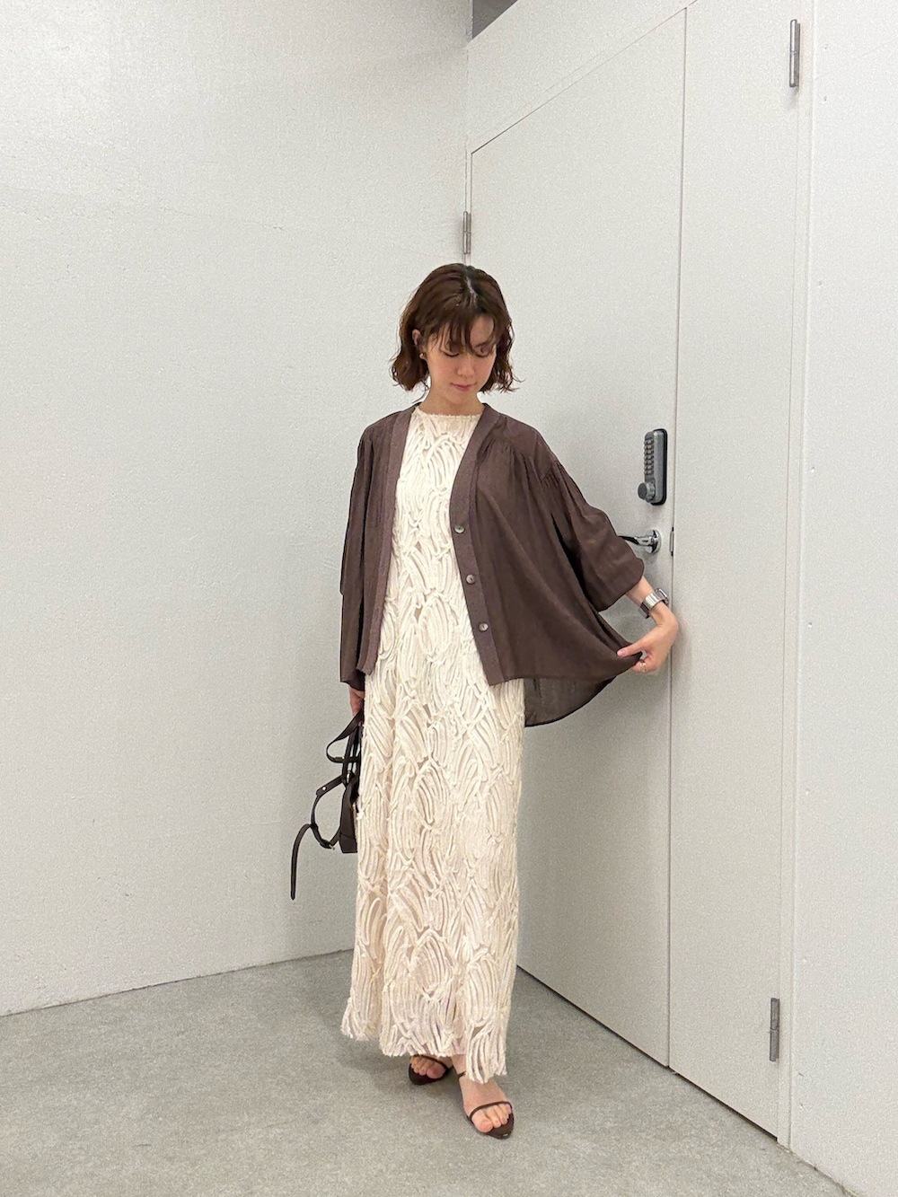 ブラウン系のシャツ/ブラウス、ホワイト系のワンピース、ブラウン系のショルダーバッグを着用したレディースの夏コーディネートの5枚目の写真
