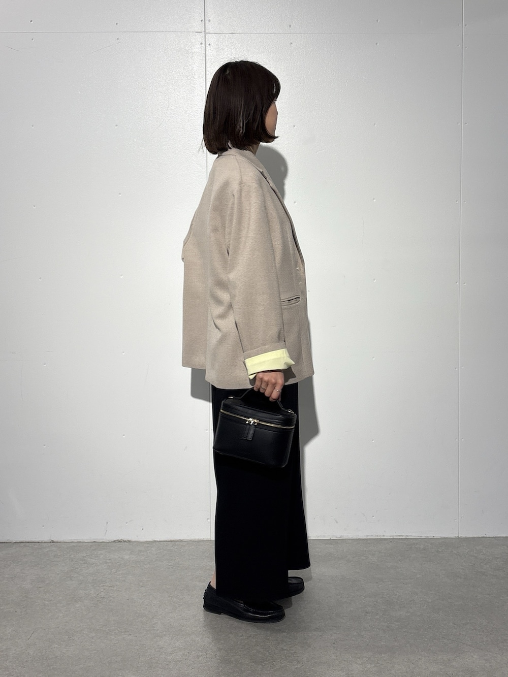 ベージュ系のテーラードジャケット、ブラック系のスカート、ホワイト系のTシャツ/カットソーを着用したレディースの冬コーディネートの2枚目の写真