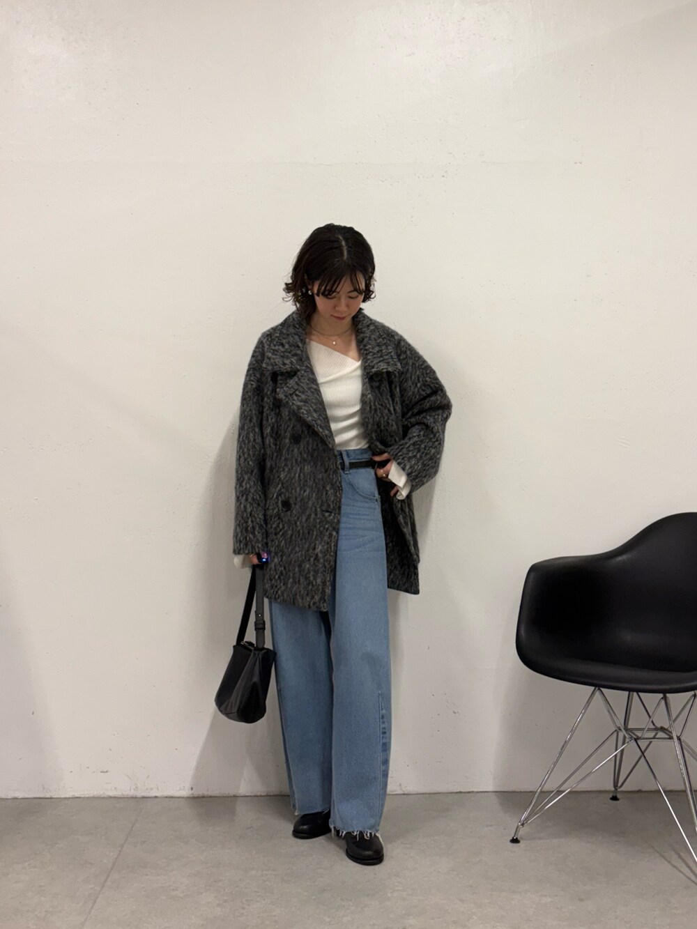 ホワイト系のニット/セーター、ブルー系のデニムパンツ、ブラック系のショルダーバッグを着用したレディースの秋コーディネートの4枚目の写真