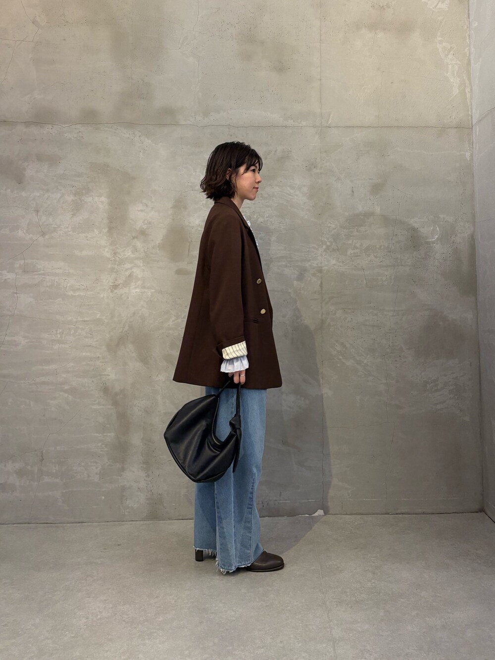 ブルー系のシャツ/ブラウス、ブルー系のデニムパンツ、ブラック系のショルダーバッグを着用したレディースの秋コーディネートの2枚目の写真