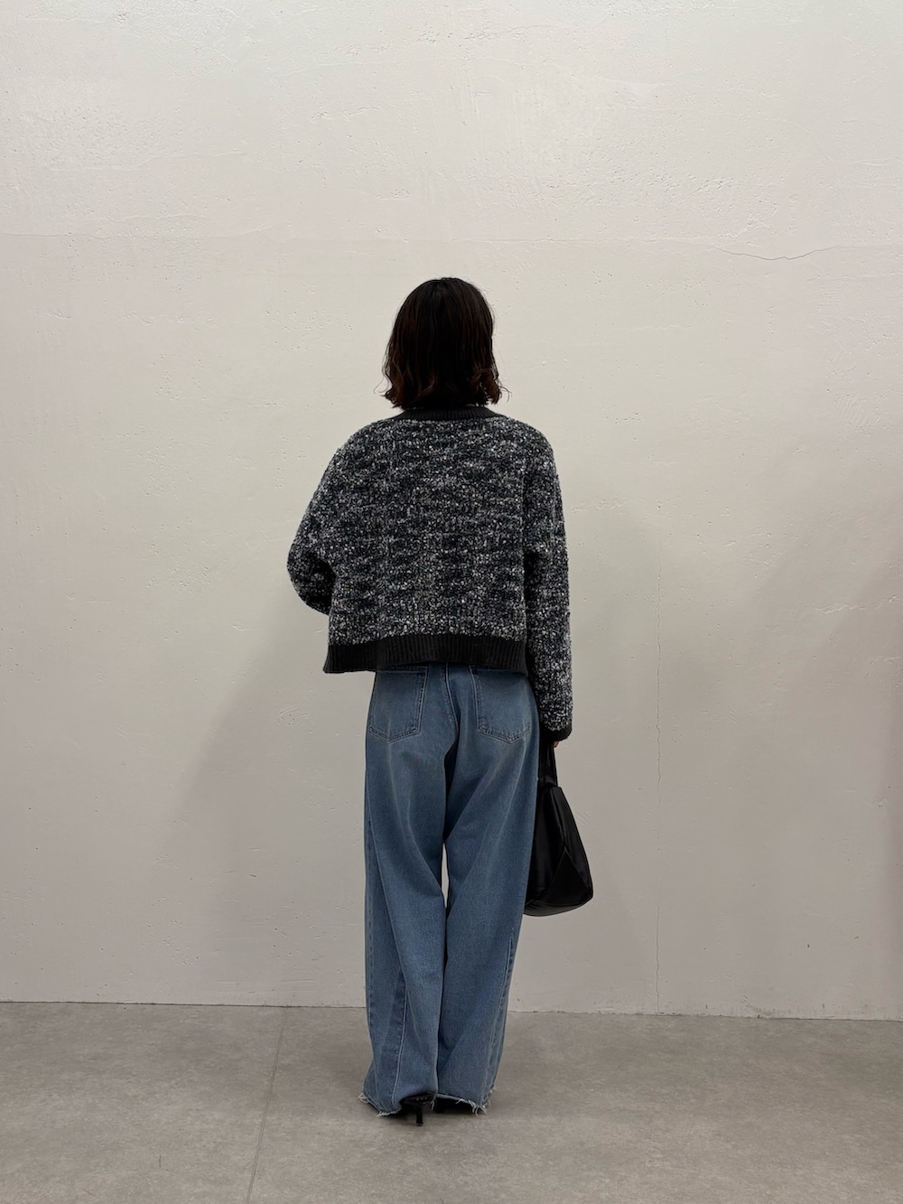 ブラック系のパンプス、ブラック系のショルダーバッグ、ホワイト系のTシャツ/カットソーを着用したレディースの秋コーディネートの3枚目の写真