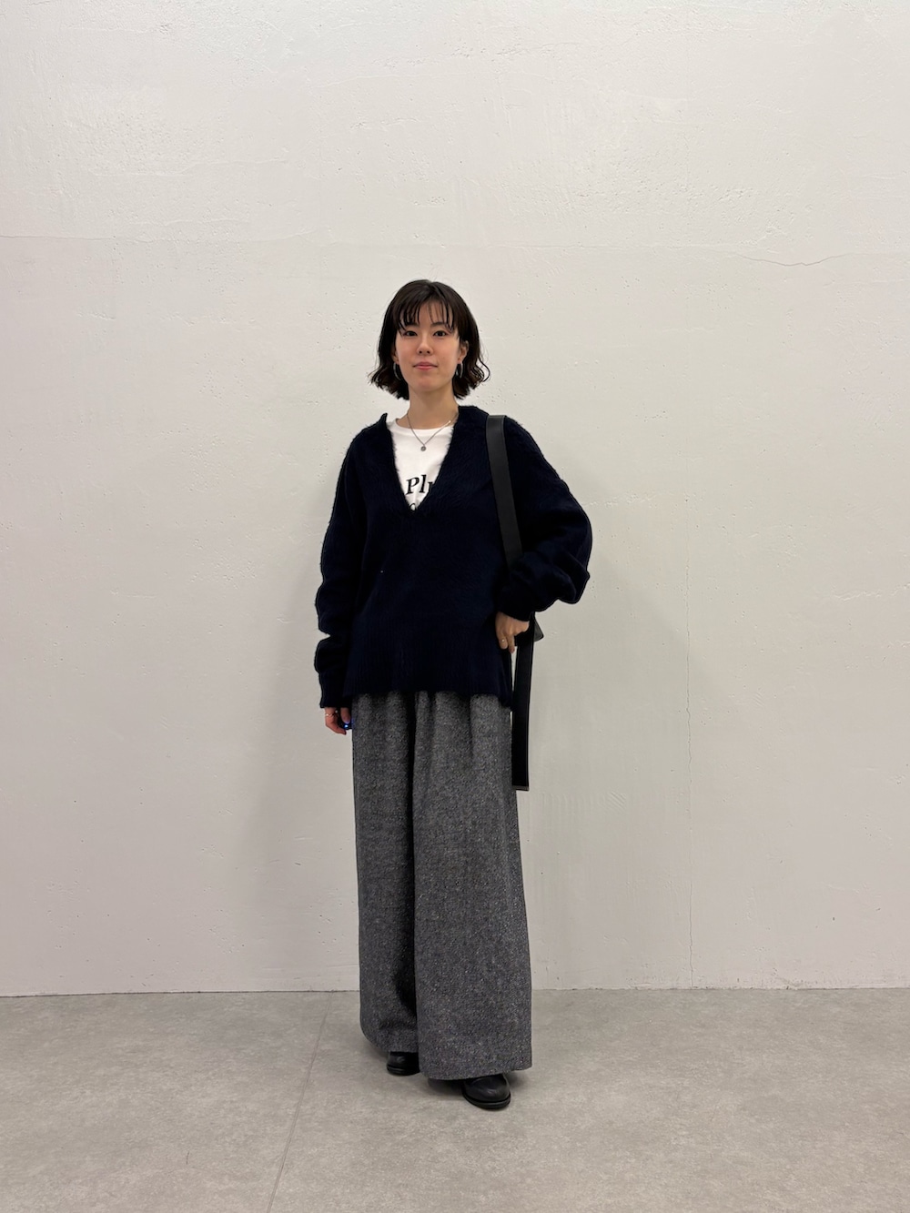 ブラック系のデニムパンツ、ホワイト系のTシャツ/カットソー、ブルー系のニット/セーターを着用したレディースの秋コーディネートの4枚目の写真