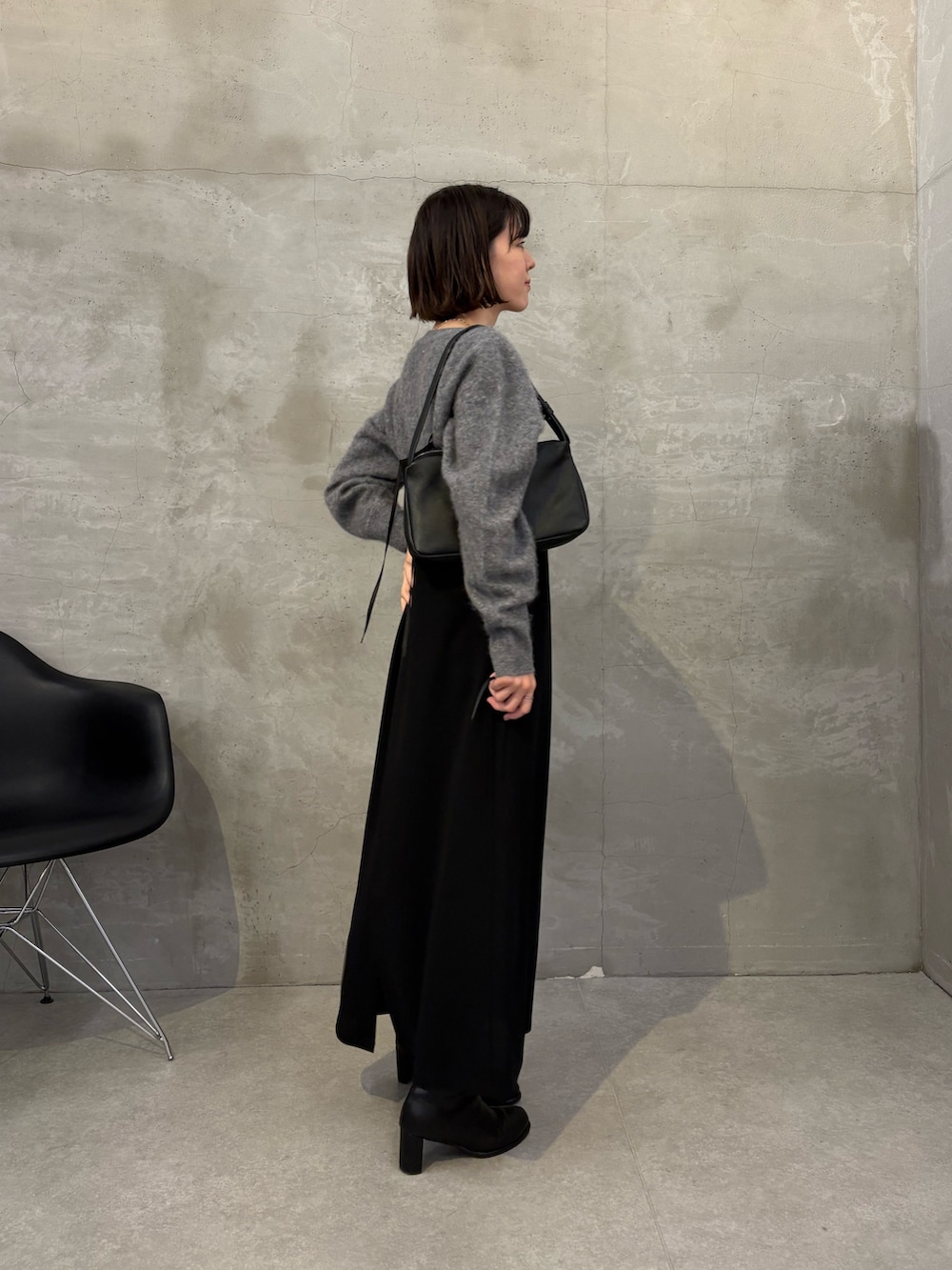 ブラック系のワンピース、グレー系のニット/セーター、ブラック系のショルダーバッグを着用したレディースの秋コーディネートの4枚目の写真