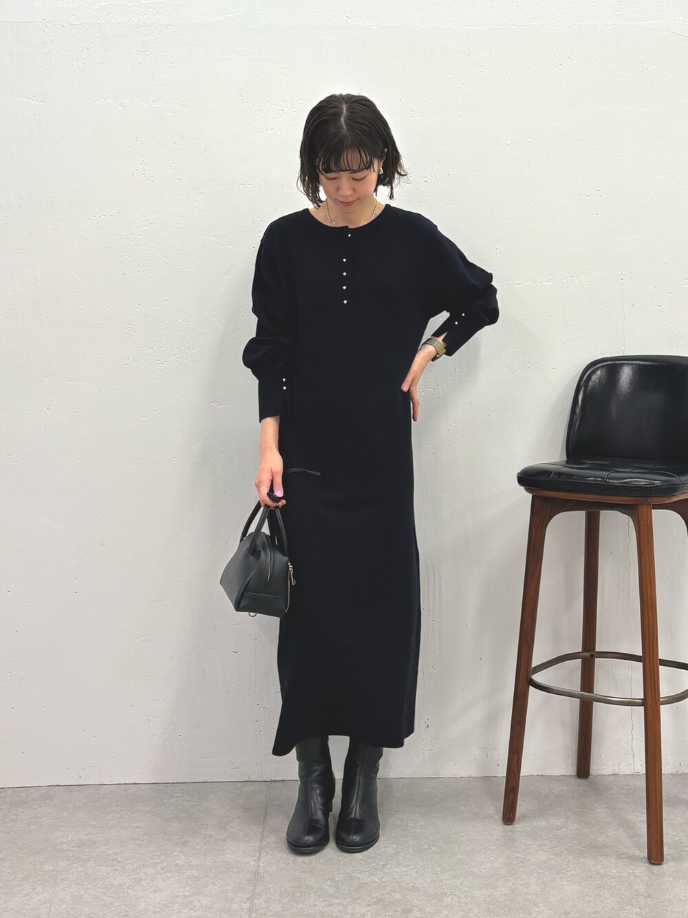 ブルー系のワンピース、ブラック系のブーツ、ブラック系のボストンバッグを着用したレディースの秋コーディネートの5枚目の写真