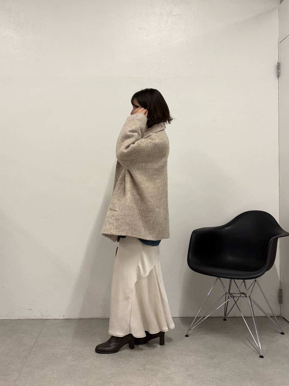 ホワイト系のスカート、ブラウン系のボストンバッグ、ブラウン系のブーツを着用したレディースの秋コーディネートの3枚目の写真