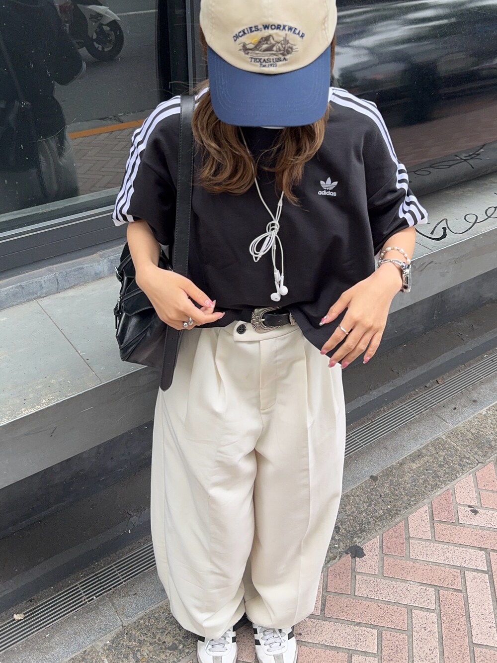 ブラック系のTシャツ/カットソー、ホワイト系のスニーカー、ホワイト系のキャップを着用したレディースの夏コーディネートの3枚目の写真