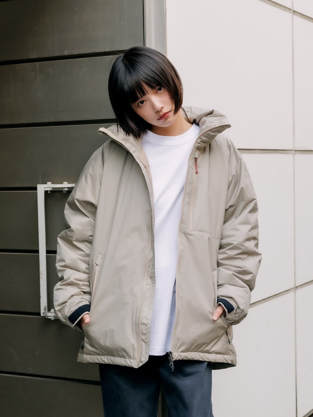 ベージュ系のダウンジャケット/コート、ホワイト系のスウェット、ブルー系のデニムパンツを着用したレディースの冬コーディネートの2枚目の写真