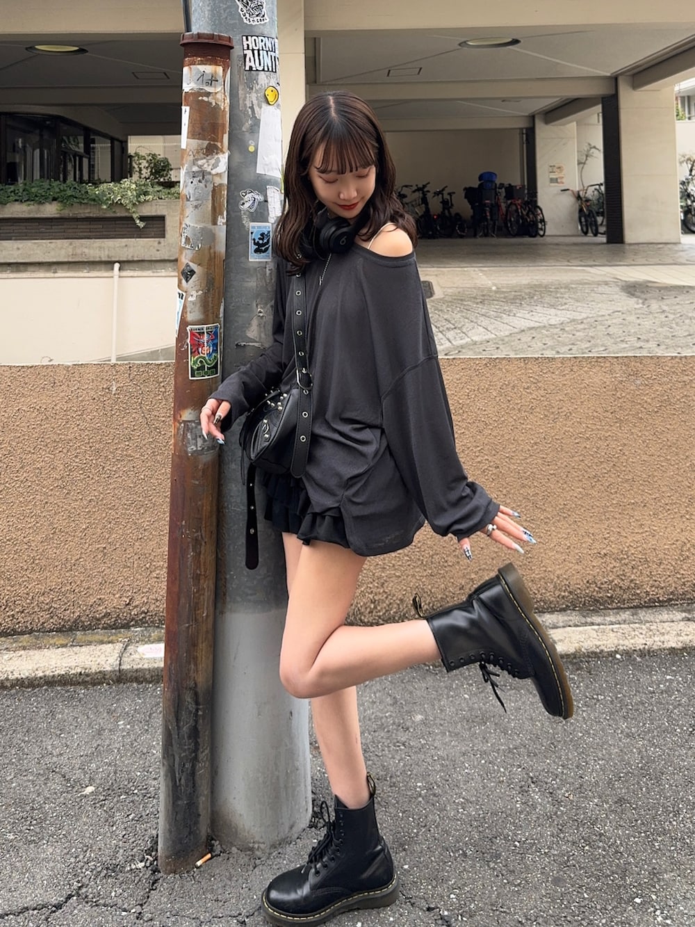 ブラック系のスカート、ブラック系のショルダーバッグ、グレー系のTシャツ/カットソーを着用したレディースの秋コーディネートの2枚目の写真