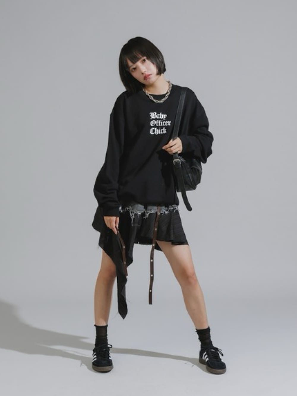 ブラック系のスウェット、ブラック系のデニムスカート、ブラック系のスニーカーを着用したレディースの秋コーディネートの2枚目の写真