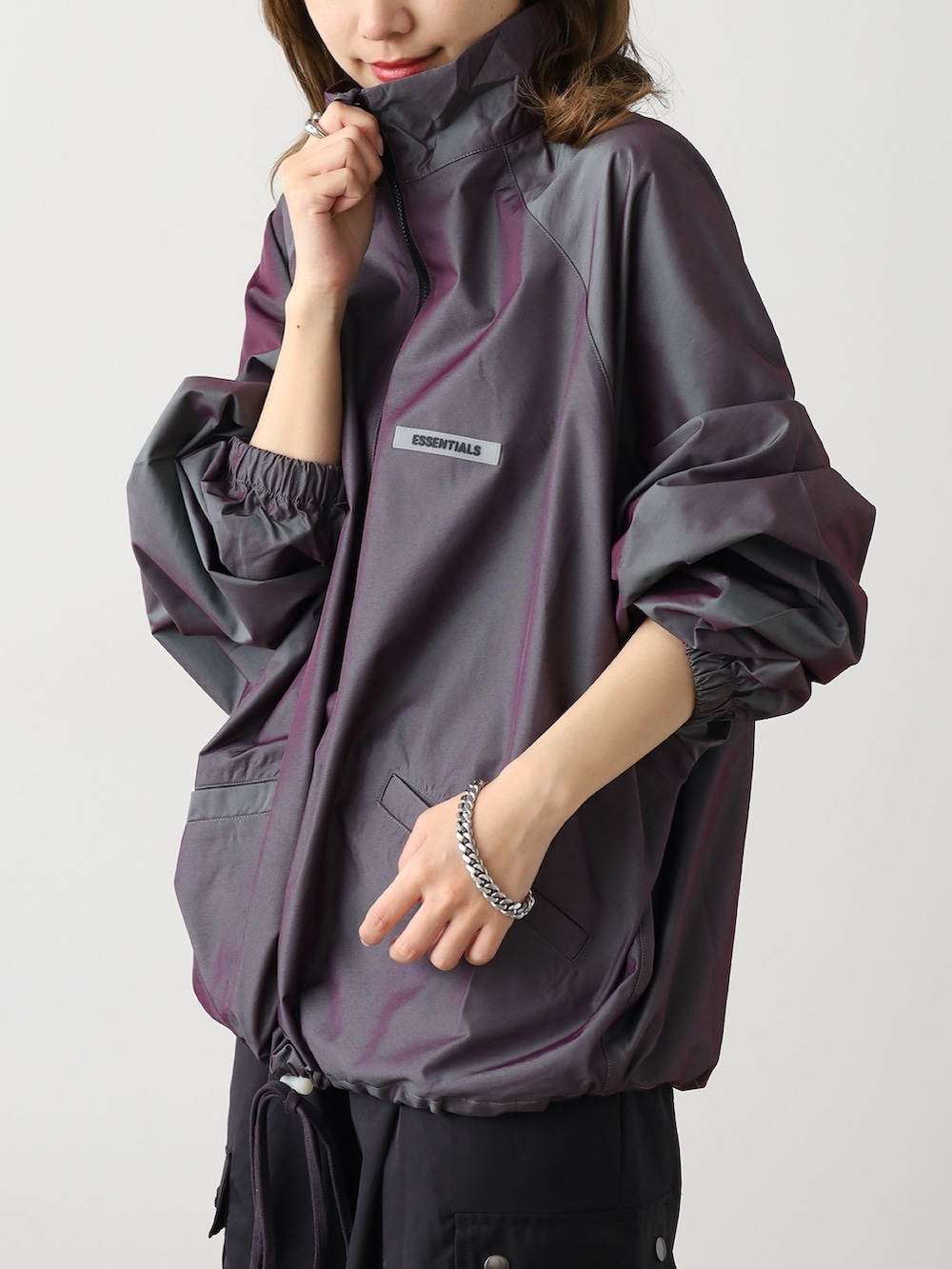 パープル系のブルゾン、ブラック系のカーゴパンツ、ホワイト系のスニーカーを着用したレディースの秋コーディネートの3枚目の写真