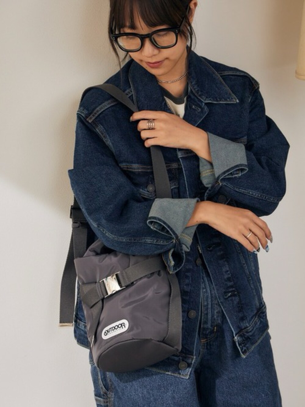 ベージュ系のTシャツ/カットソー、ブルー系のデニムジャケット、ブルー系のデニムパンツを着用したレディースの秋コーディネートの2枚目の写真