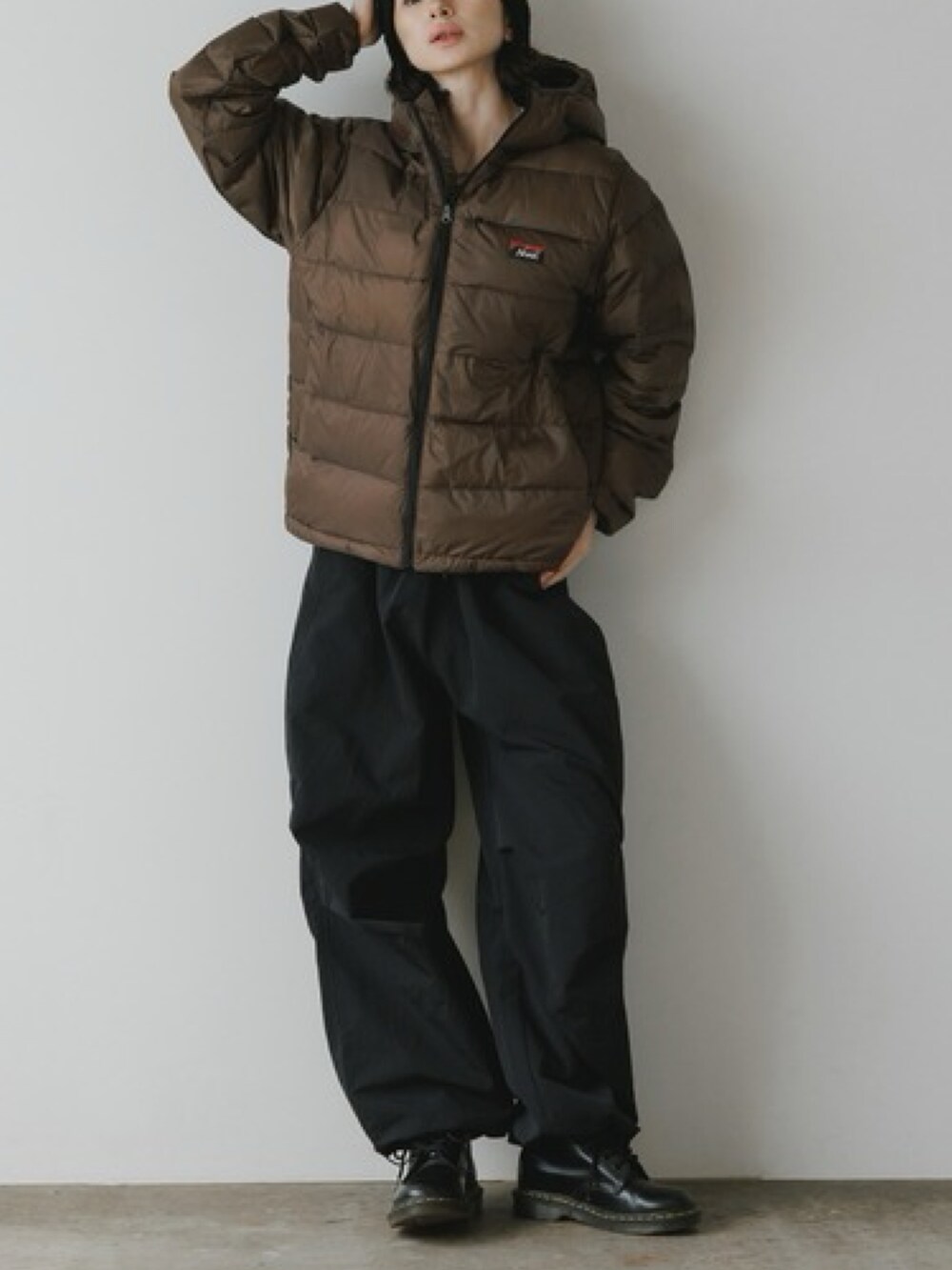 ブラウン系のダウンジャケット/コート、ブラック系のカーゴパンツ、ブラック系のブーツを着用したレディースの秋コーディネートの2枚目の写真