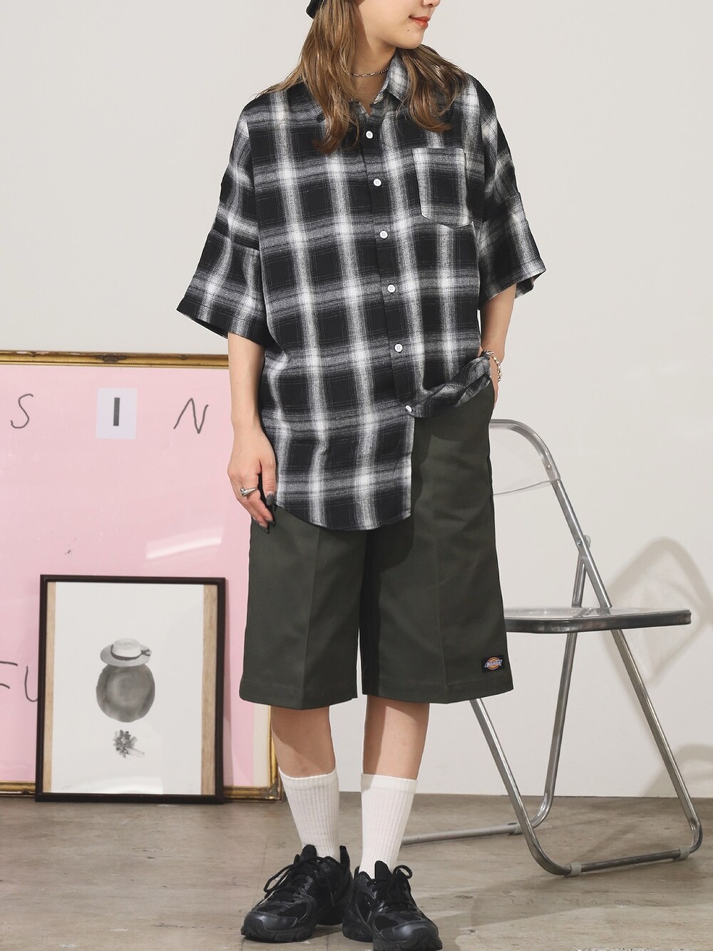 グリーン系のチノパンツ、ブラック系のシャツ/ブラウス、シルバー系のブレスレットを着用したレディースの夏コーディネートの2枚目の写真