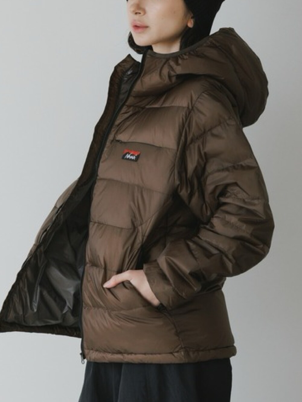 ブラウン系のダウンジャケット/コート、ブラック系のカーゴパンツ、ブラック系のブーツを着用したレディースの秋コーディネートの3枚目の写真