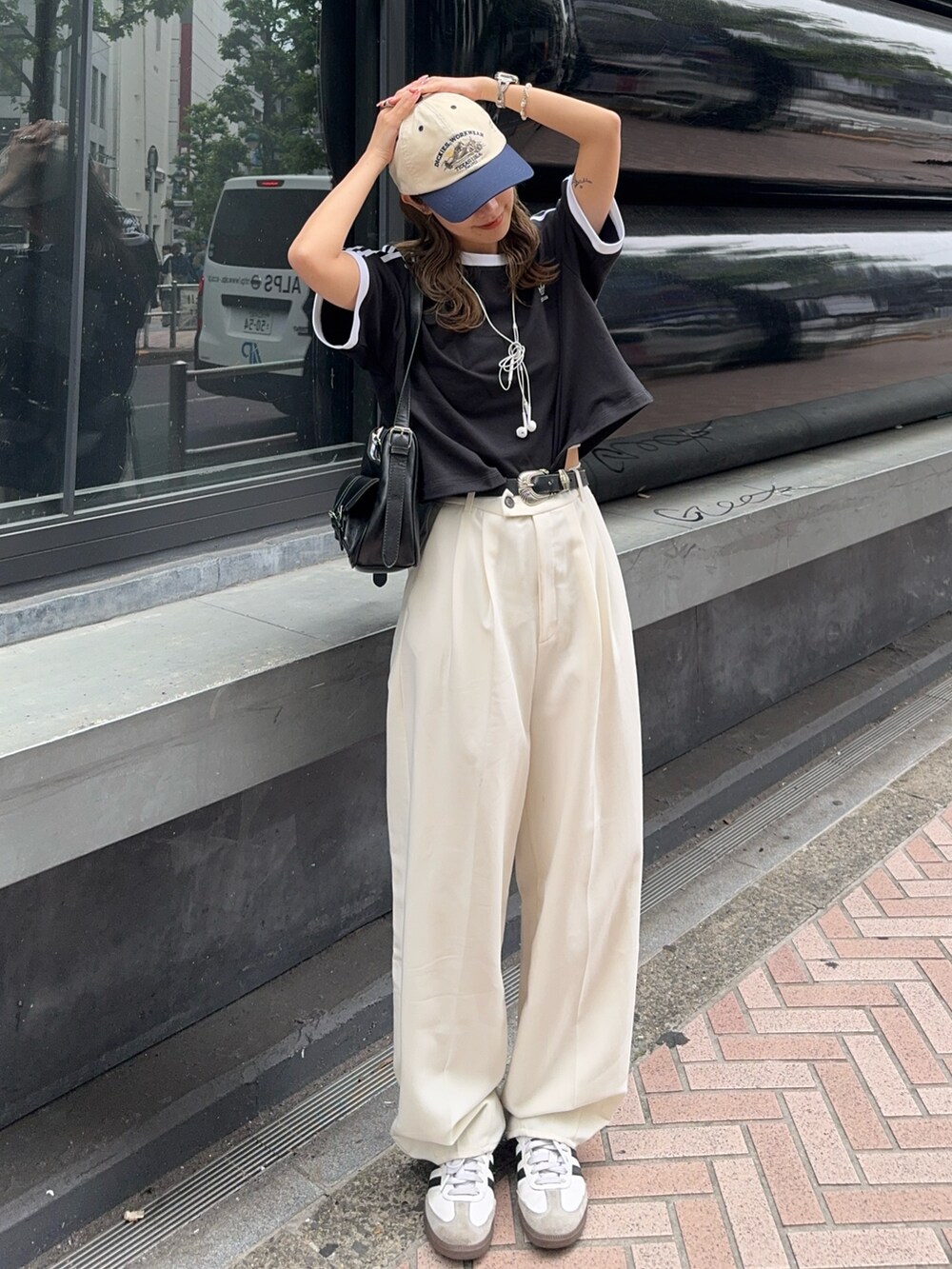 ブラック系のTシャツ/カットソー、ホワイト系のスニーカー、ホワイト系のキャップを着用したレディースの夏コーディネートの2枚目の写真