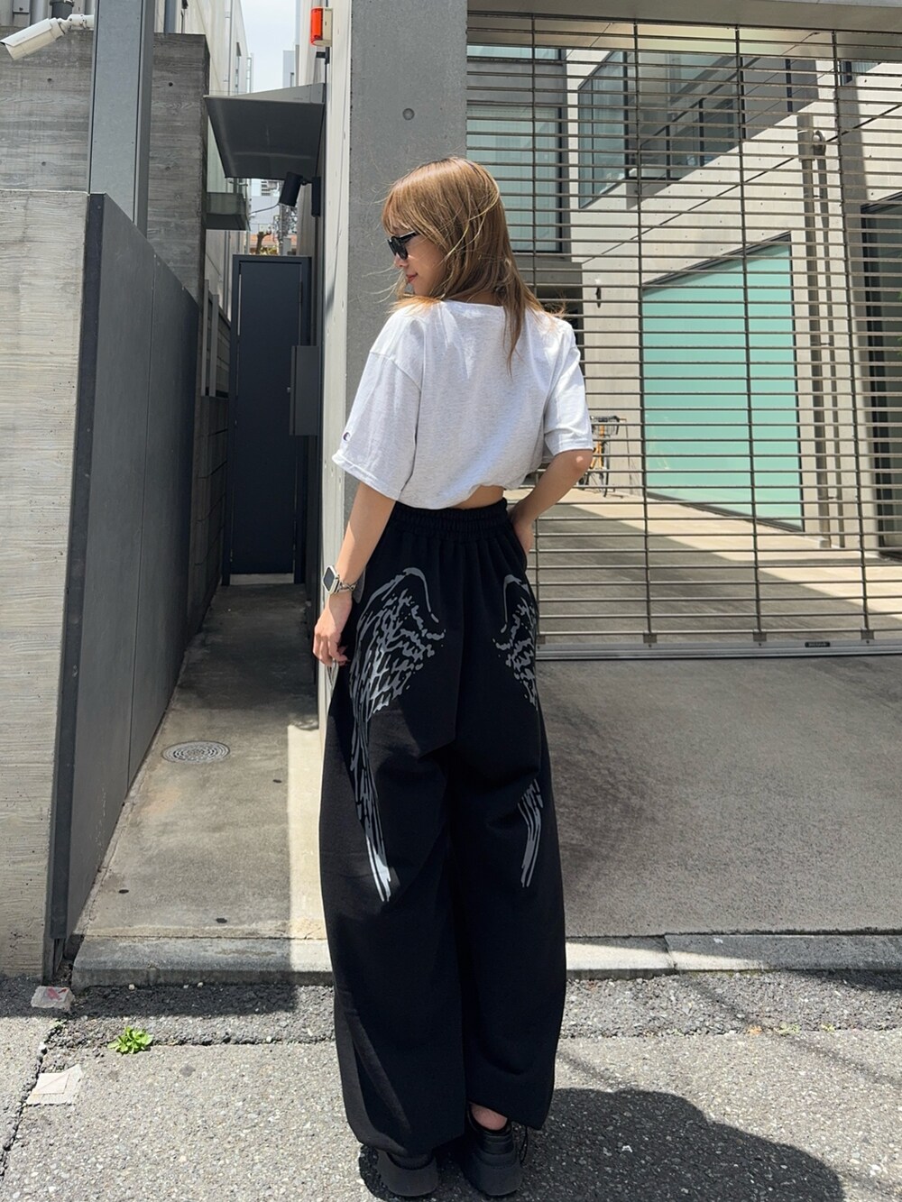 グレー系のTシャツ/カットソー、ブラック系のスウェットパンツを着用したレディースの夏コーディネートの2枚目の写真