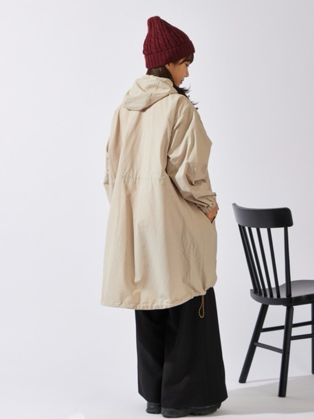 ベージュ系のマウンテンパーカー、ブラック系のスラックス、ブラック系のスニーカーを着用したレディースの秋コーディネートの2枚目の写真