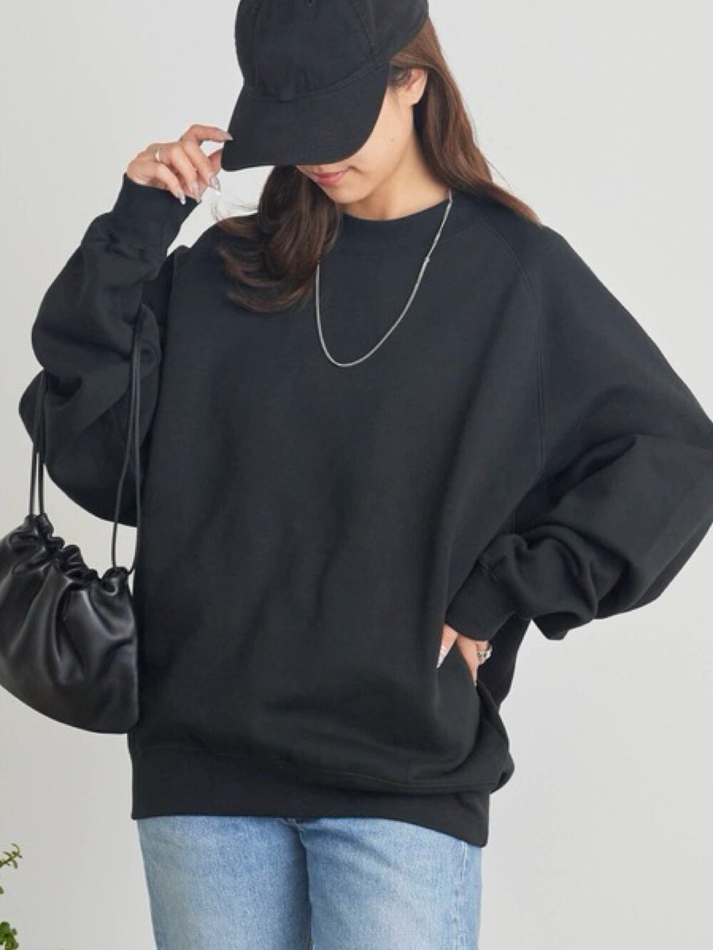 ブラック系のスウェット、ブルー系のデニムパンツを着用したレディースの秋コーディネートの3枚目の写真